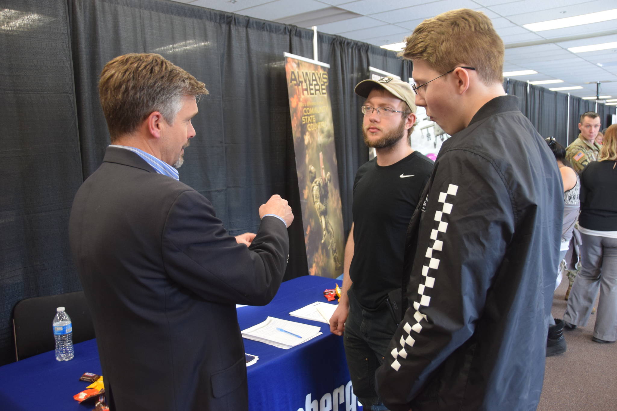 Florian Borowski with Schlumberger Oilfield Services speaks with potential recruits at the Peninsula Job Fair at the Soldotna Regional Sports Complex in Soldotna, Alaska, on March 21, 2019. (Photo by Brian Mazurek/Peninsula Clarion)
