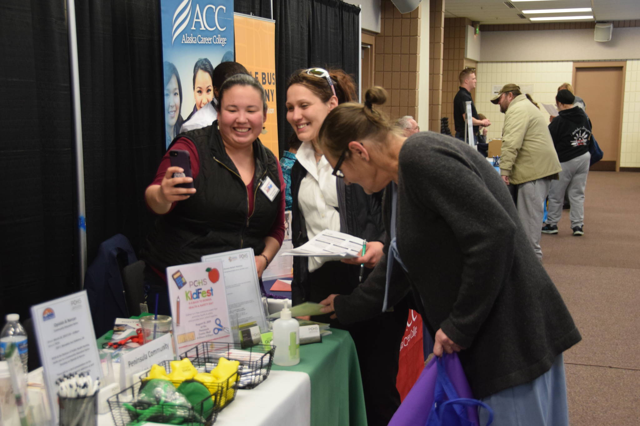 A Peninsula Community Health Services representative takes a selfie with a potential new hire during the Peninsula Job Fair at the Soldotna Regional Sports Complex in Soldotna, Alaska, on March 21, 2019. (Photo by Brian Mazurek/Peninsula Clarion)