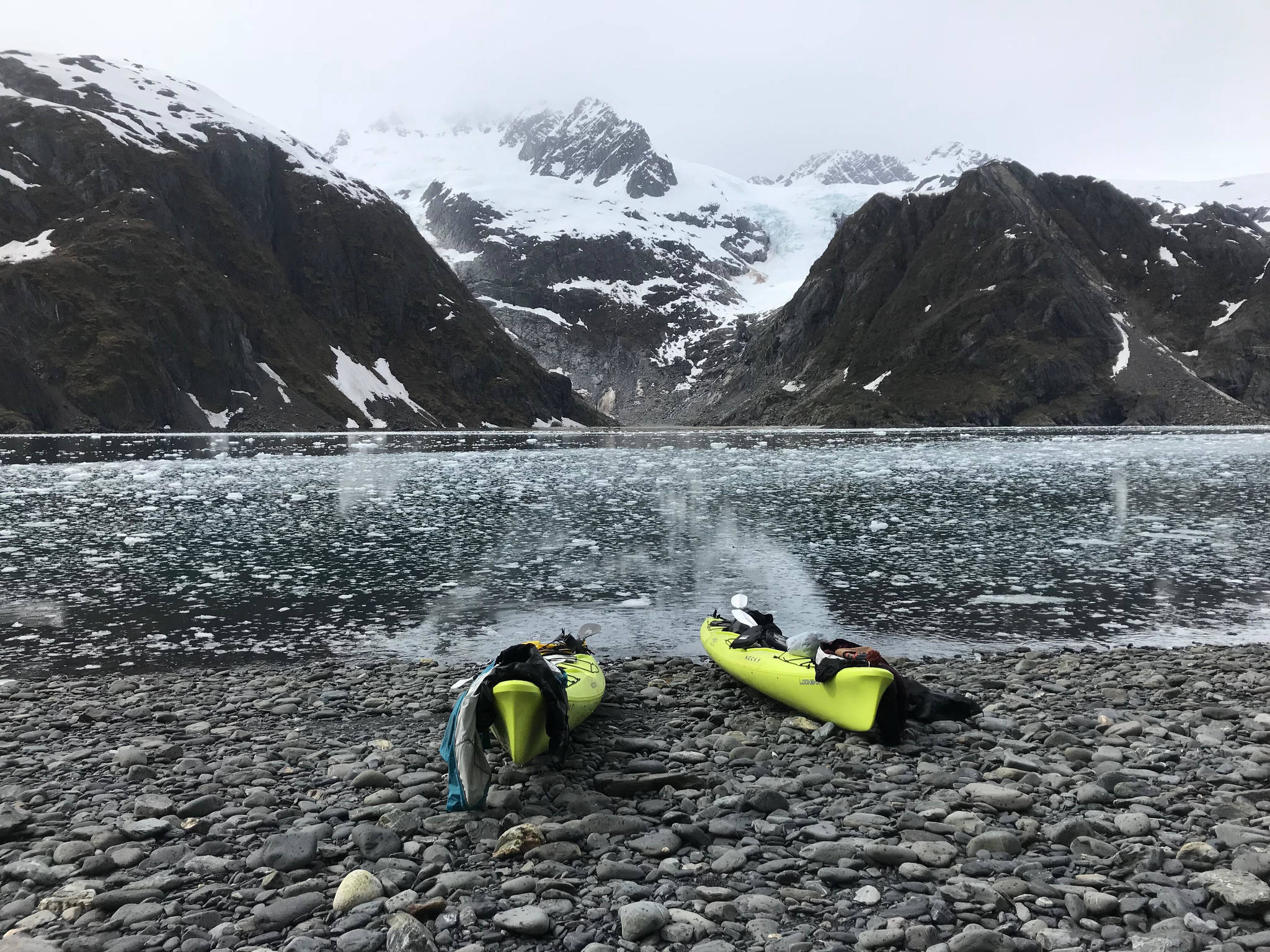 Two kayaks sit on a beach in Aialik Bay during a trip with Liquid Adventures kayaking company, based in Seward, in summer 2018. (Photo by Kat Sorensen/Peninsula Clarion)