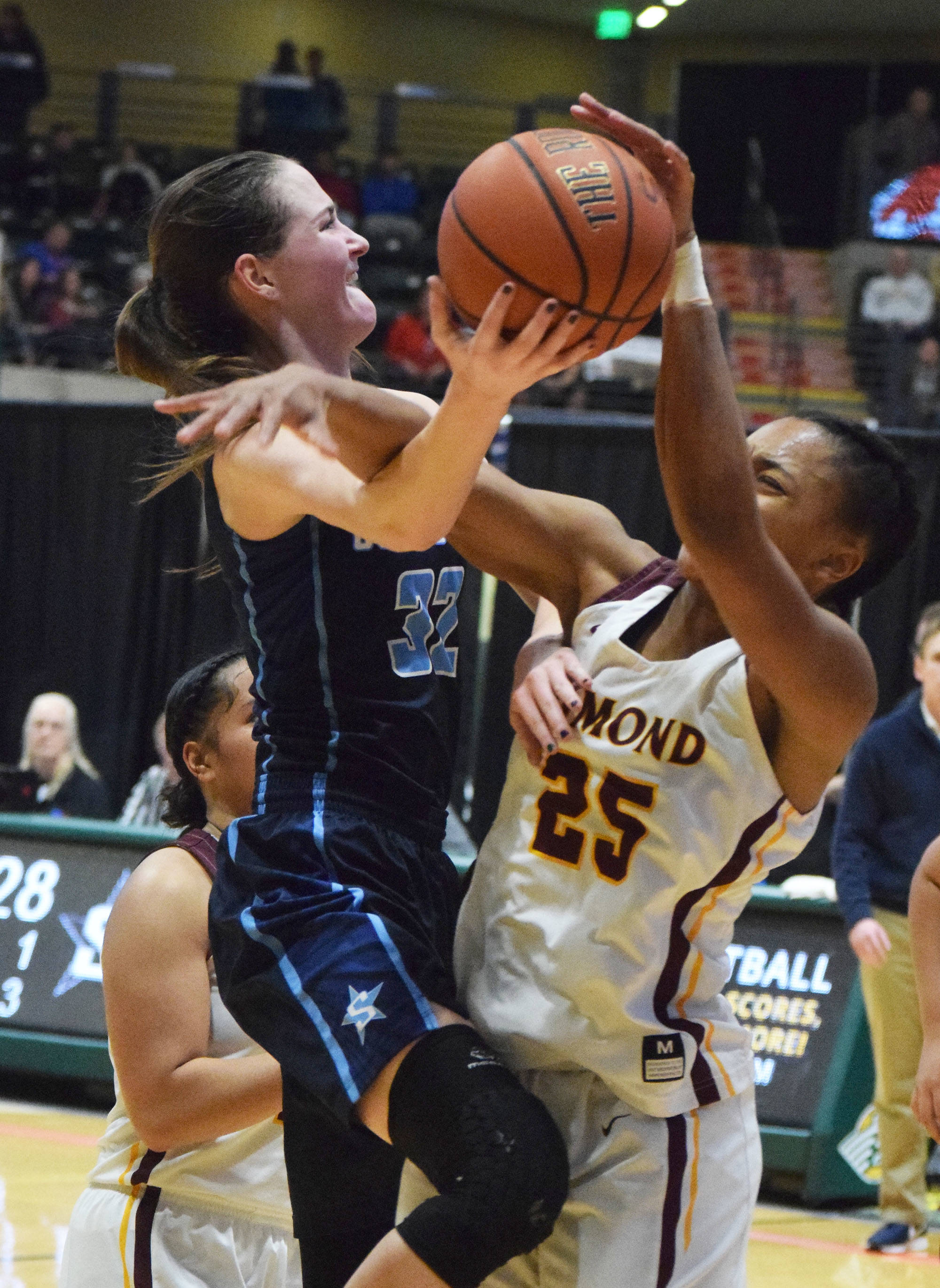 Soldotna’s Danica Schmidt receives a block from Dimond’s Ahvionn Rabb Friday, March 22, 2019, in the Class 4A state basketball tournament at the Alaska Airlines Center in Anchorage. (Photo by Joey Klecka/Peninsula Clarion)