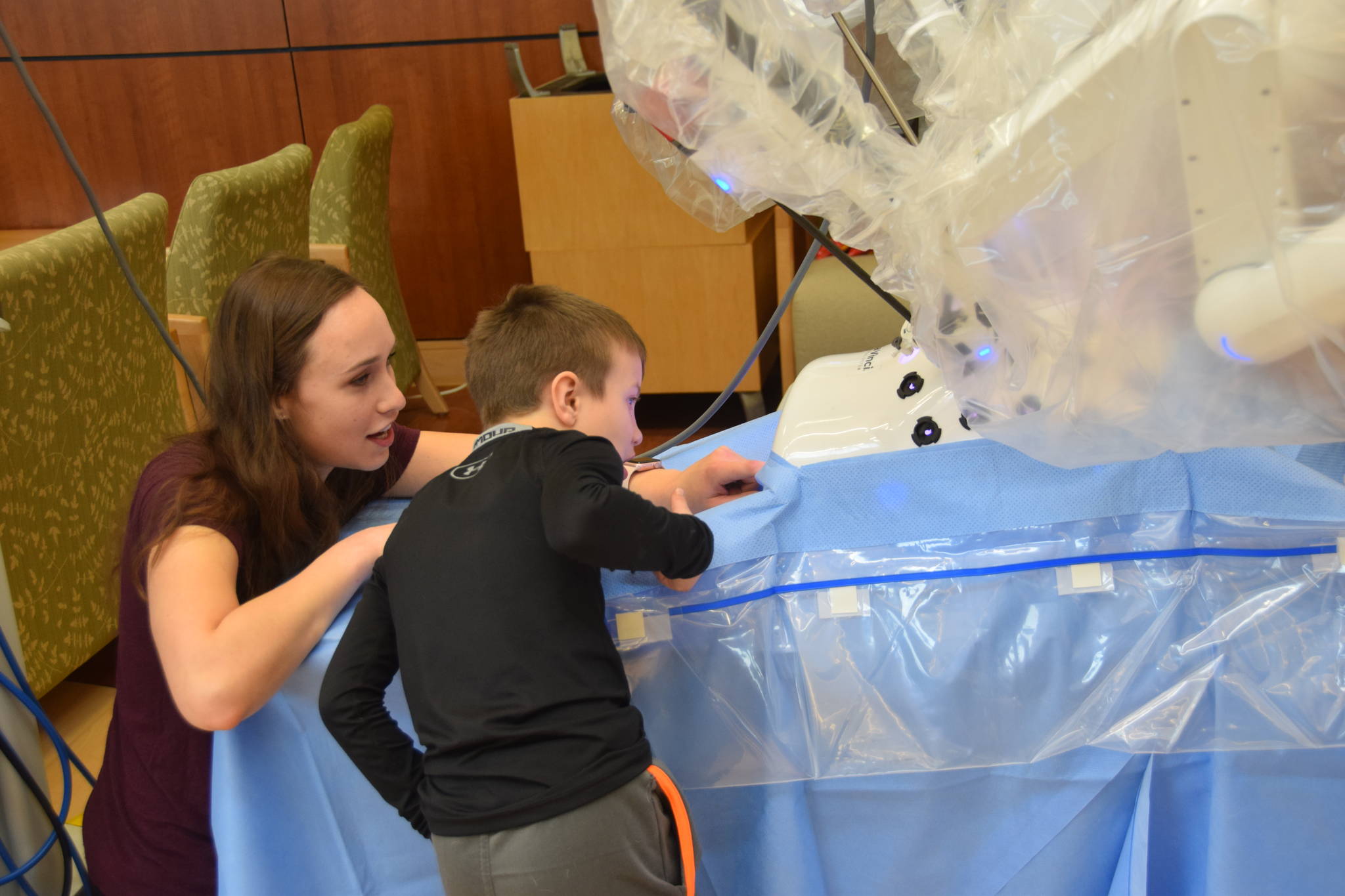 RN Sage Davenport shows a young fairgoer how the Da Vinci Xi works during the Community Health Fair at Central Peninsula Hospital in Soldotna, Alaska, on March 23, 2019. (Photo by Brian Mazurek/Peninsula Clarion)