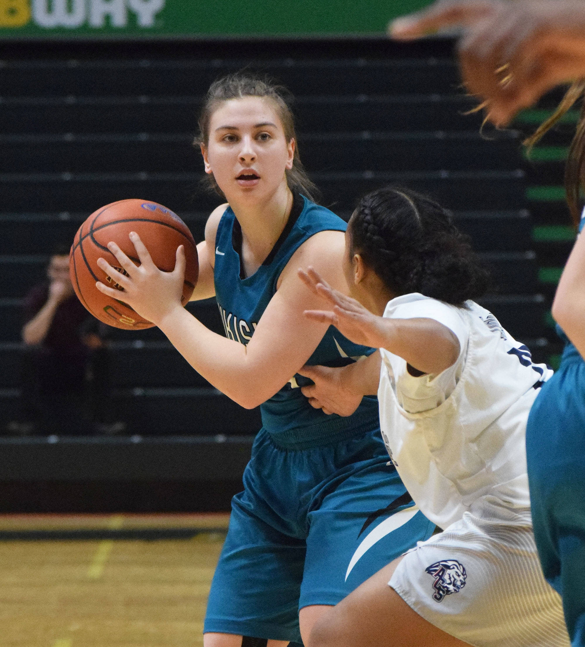 Nikiski’s Kelsey Clark looks for an open teammate in front of an ACS defender Saturday, March 23, 2019, in the Class 3A girls state basketball championship at the Alaska Airlines Center in Anchorage. (Photo by Joey Klecka/Peninsula Clarion)
