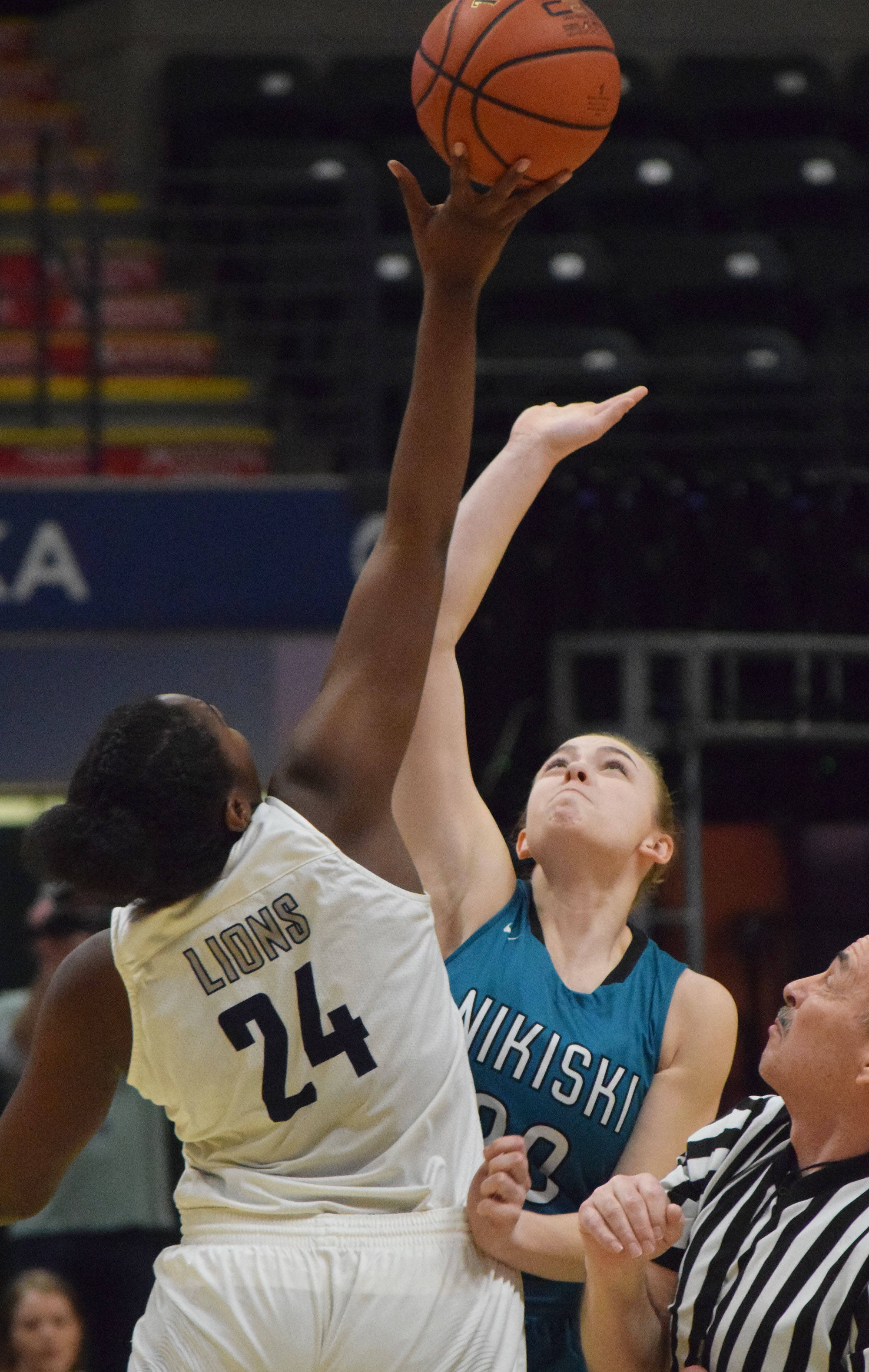 Nikiski’s Bethany Carstens (right) and ACS’s Jordan Todd tip off to begin Saturday’s Class 3A girls state basketball championship at the Alaska Airlines Center in Anchorage. (Photo by Joey Klecka/Peninsula Clarion)
