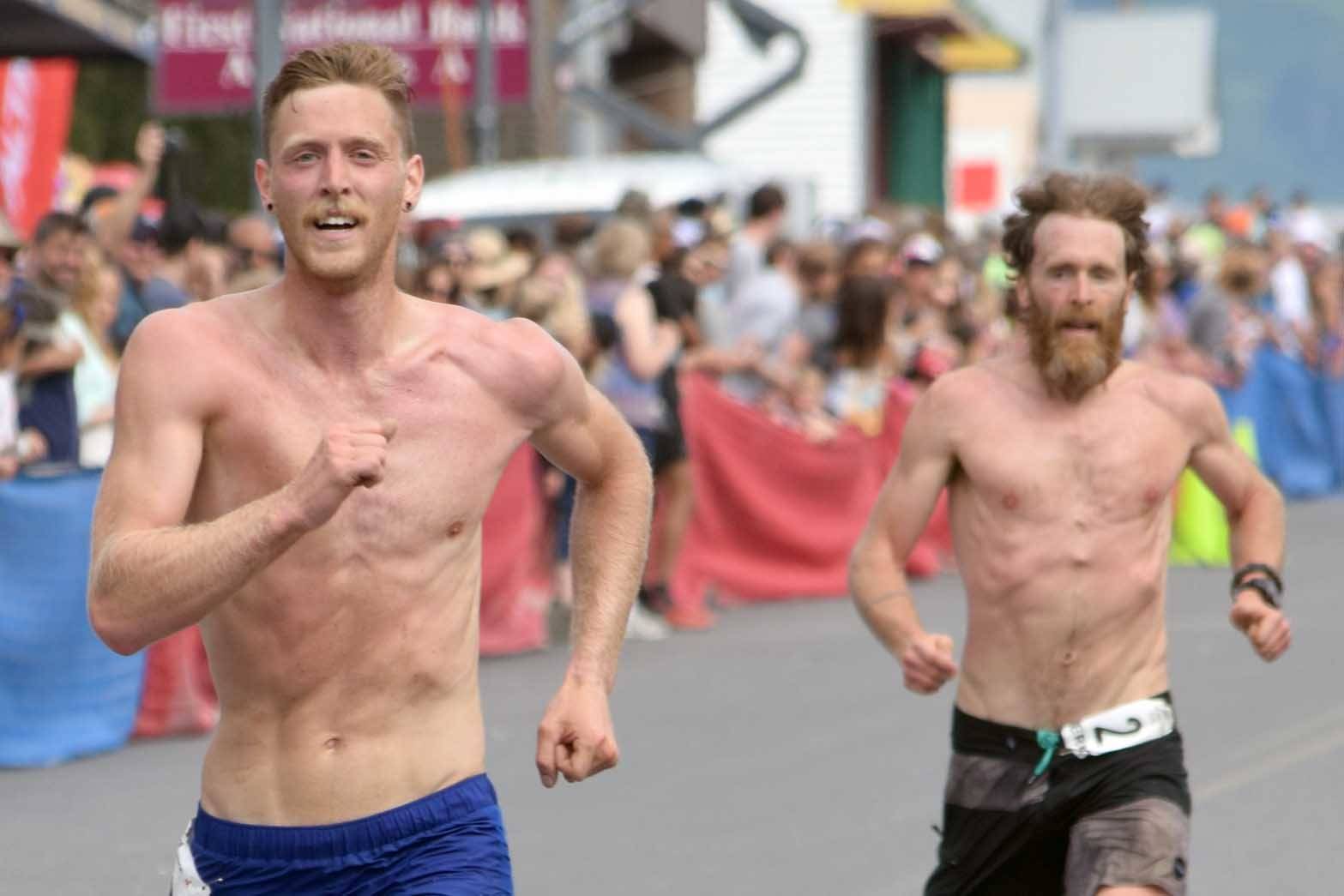 Anchorage’s Lars Arneson, a 2009 graduate of Cook Inlet Academy, passes Seward’s Erik Johnson to take seventh place at the Mount Marathon Race on July 4, 2018, in Seward. Johnson finished eighth.(Photo by Jeff Helminiak/Peninsula Clarion)