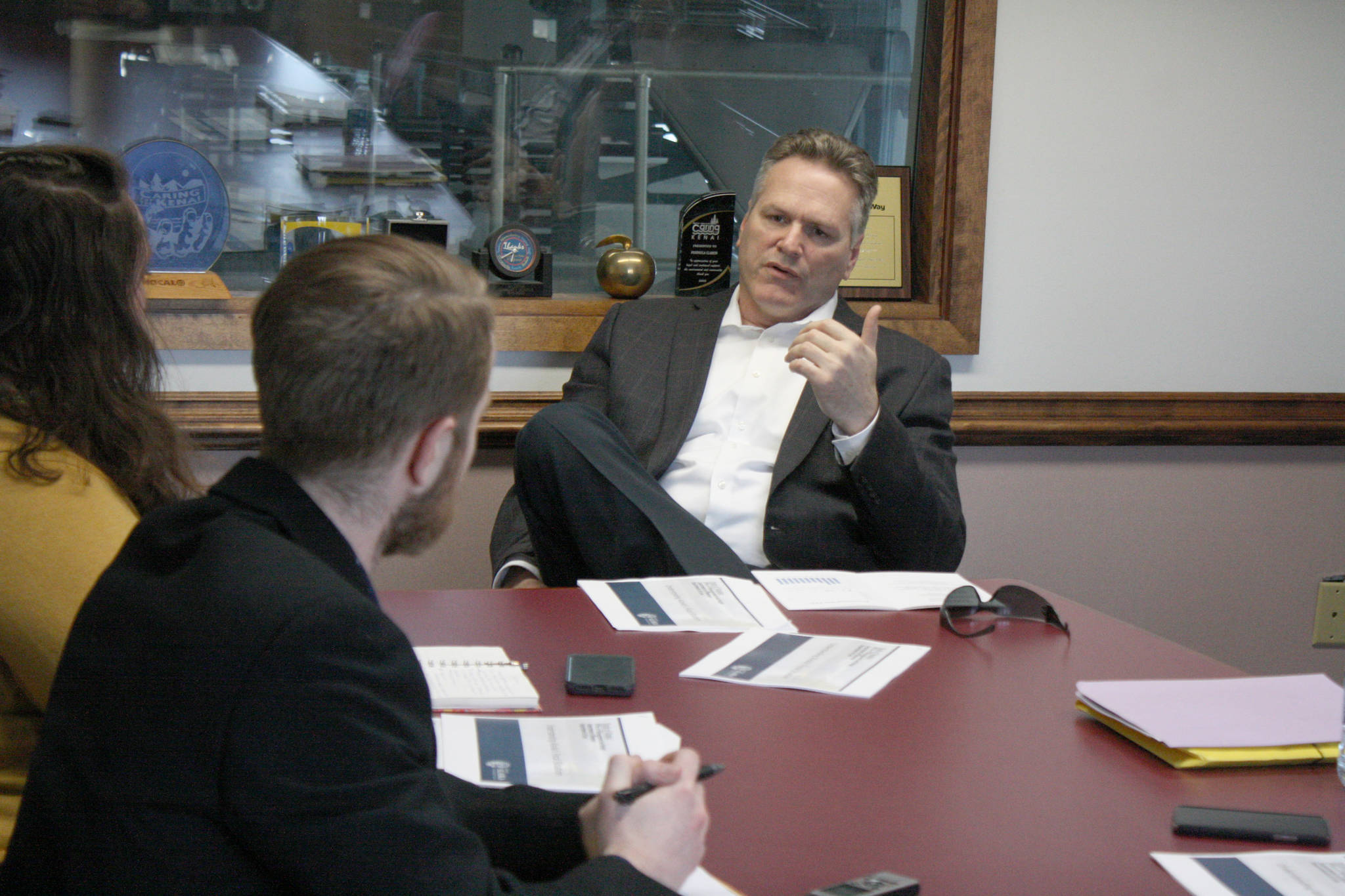 Gov. Mike Dunleavy speaks with Clarion reporters Brian Mazurek, left, and Victoria Petersen on Monday, March 25, 2019, in Kenai, Alaska. The governor answered questions on a wide range of topics, including public safety, education, industry and his proposed budget. (Photo by Erin Thompson/Peninsula Clarion)