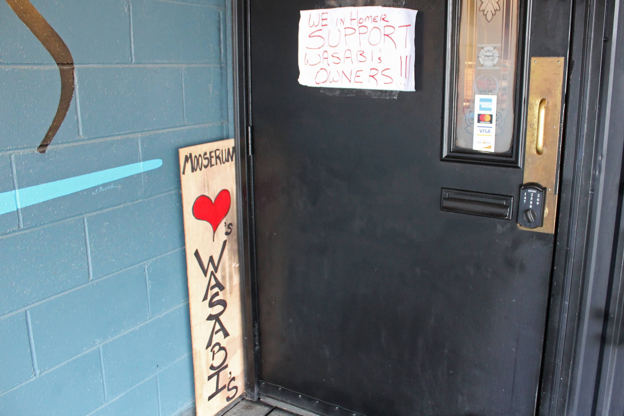 Messages of support surround the door to Wasabi’s Bistro on Thursday, March 21, 2019 in Homer, Alaska. Members of the community put up the signs and flocked to the restaurant last Thursday after the building was vandalized with racist graffiti. (Photo by Megan Pacer/Homer News)