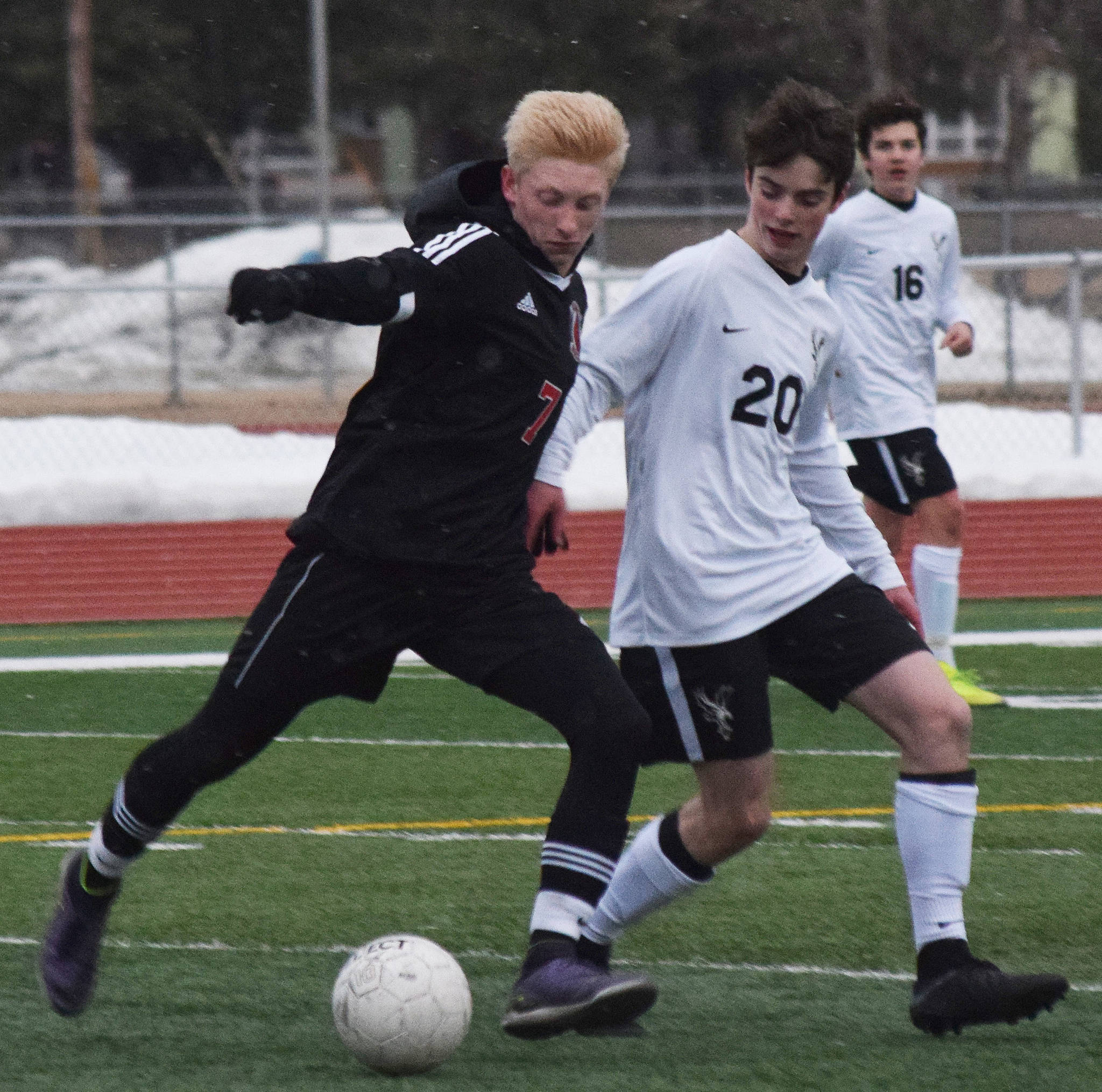 Kenai’s Leif Lofquist (left) battles with West’s Isaac Main Thursday, April 4, 2019, in a nonconference game at Kenai Central High School. (Photo by Joey Klecka/Peninsula Clarion)