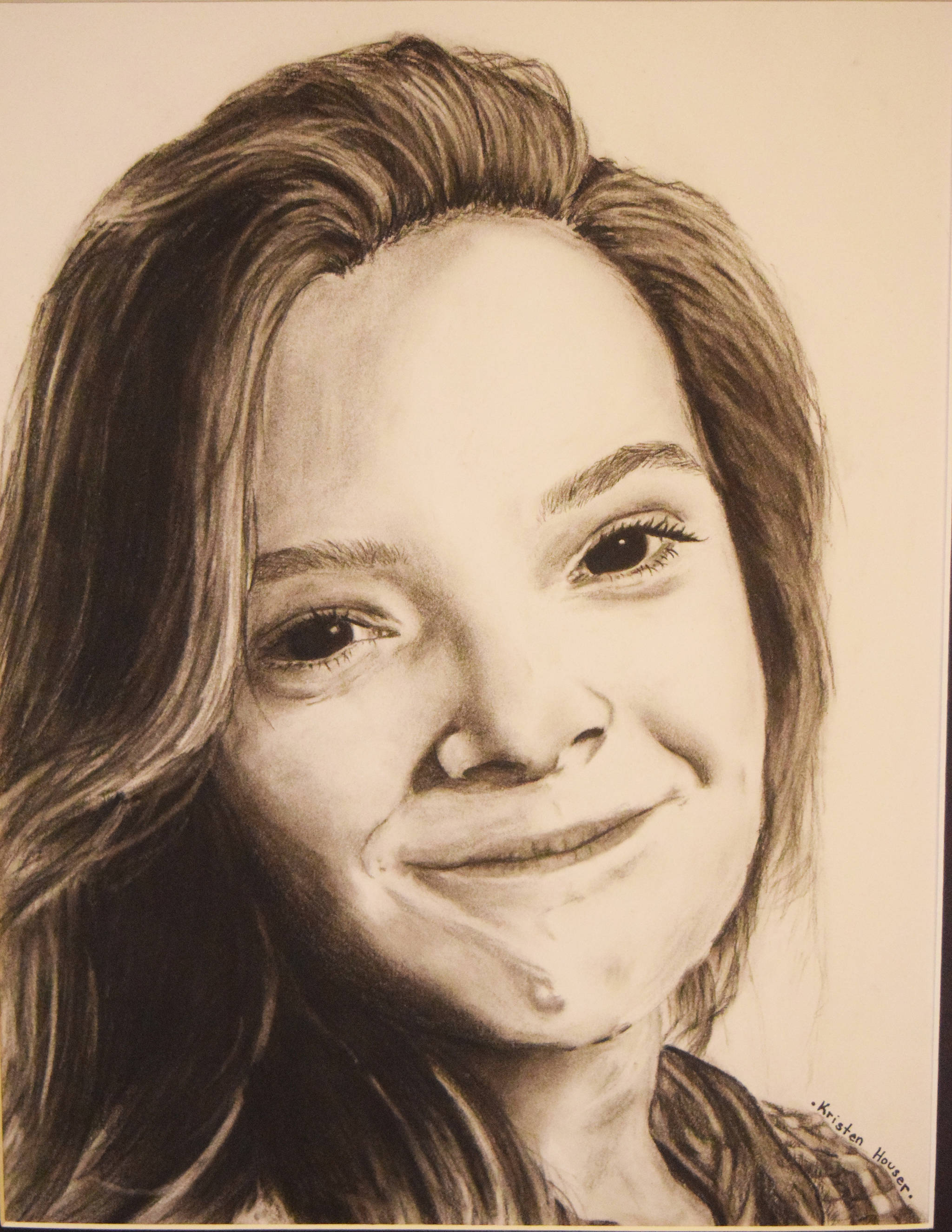 A self-portrait drawing by Skyview Middle School eighth grader Kristin Houser hangs in the gallery at the Kenai Fine Arts Center during Thursday’s opening reception of the 30th anniversary Visual Feast art show. (Photo by Joey Klecka/Peninsula Clarion)
