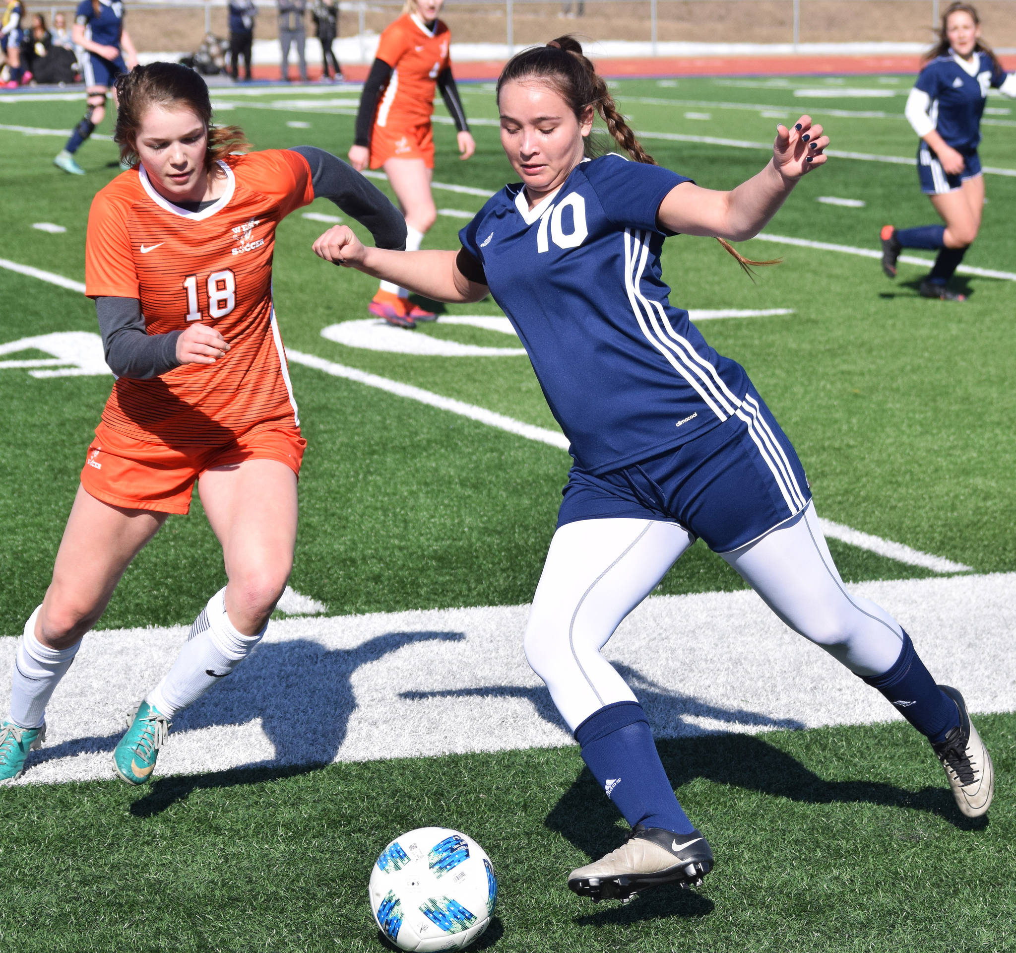 Soldotna’s Sierra Longfellow (10) races to the ball ahead of West’s Beatrix Brudie Friday, April 5, 2019, in a nonconference contest at Soldotna High School. (Photo by Joey Klecka/Peninsula Clarion)