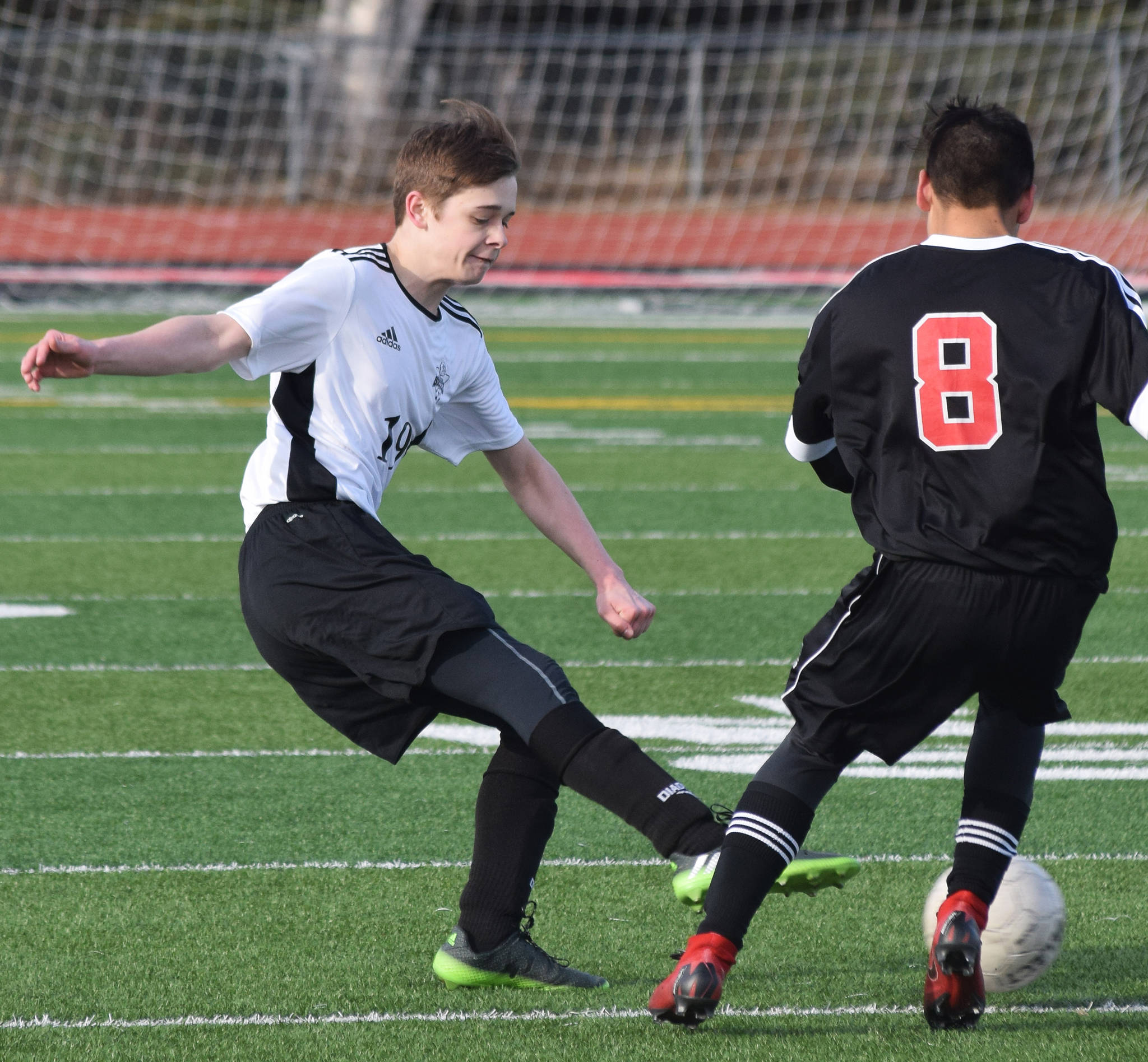 Nikiski’s Jordan Flemming (left) attempts to keep a ball away from Kenai’s Koa Diorec Thursday in a Peninsula Conference clash at Kenai Central High School. (Photo by Joey Klecka/Peninsula Clarion)