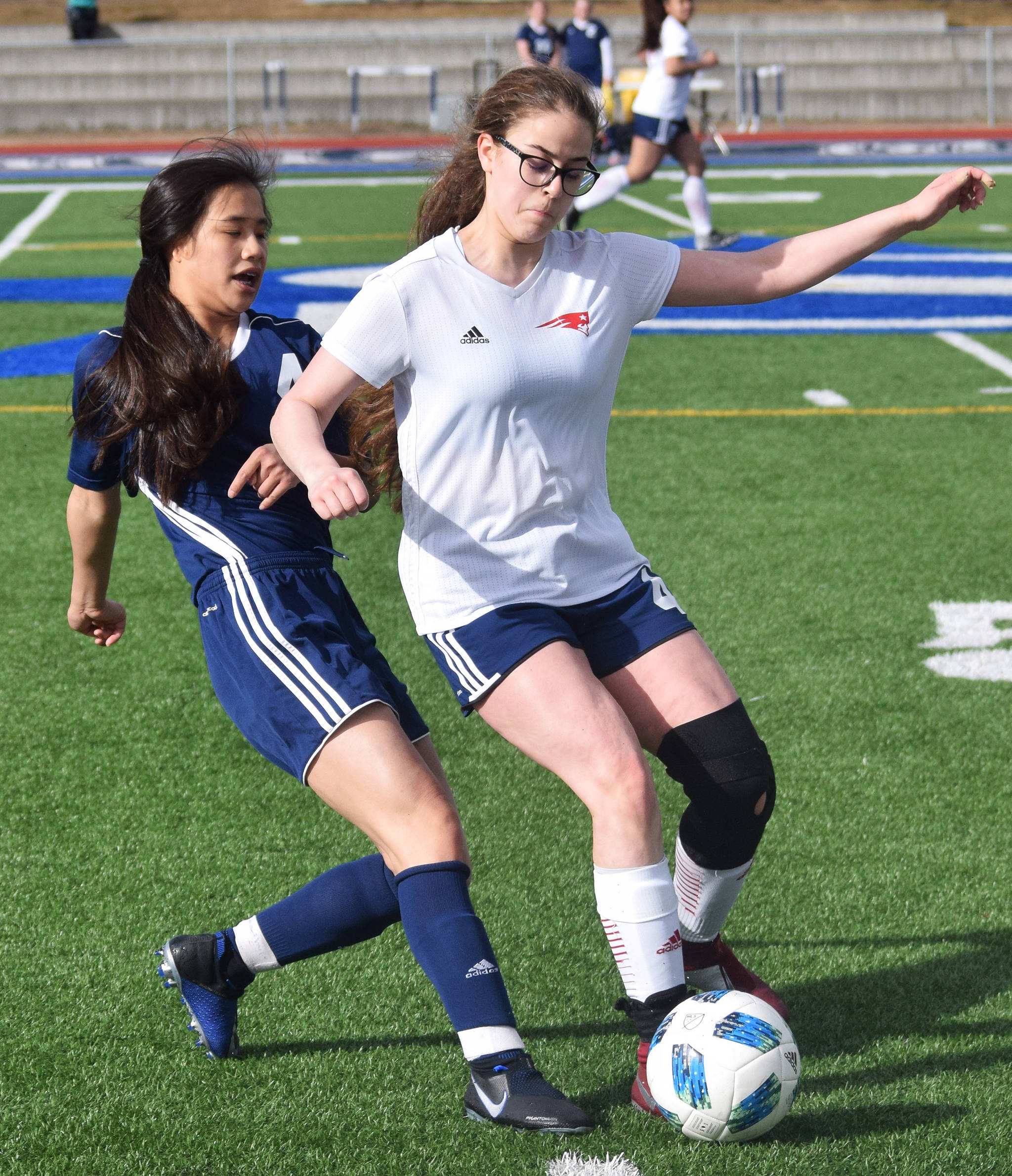 Soldotna’s Meijan Leaf (left) attempts to steal the ball from North Pole’s Abby Taylor Friday, April 12, 2019, in a nonconference game at Soldotna High School. (Photo by Joey Klecka/Peninsula Clarion)