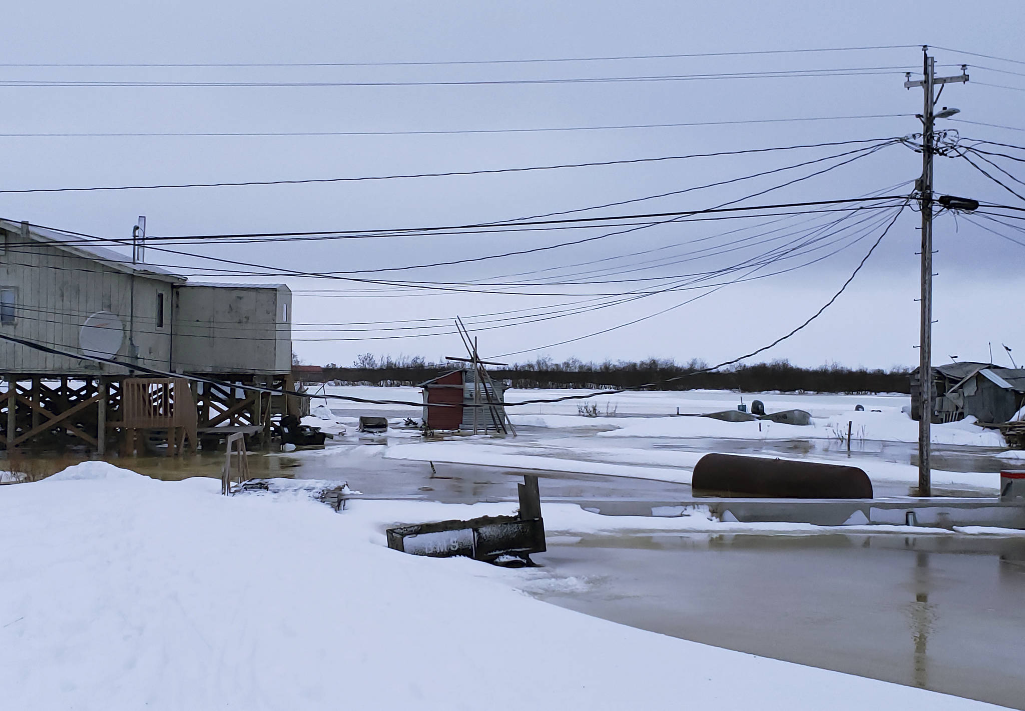 In this Feb. 12, 2019 photo provided by Philomena Keys, high water pushed up the Yukon River from the Bering Sea floods yards around homes in the western village of Kotlik, Alaska. Warm winds in February melted or pushed away Bering Sea ice, leaving coastal villages vulnerable to winter flooding. (Philomena Keys via AP)