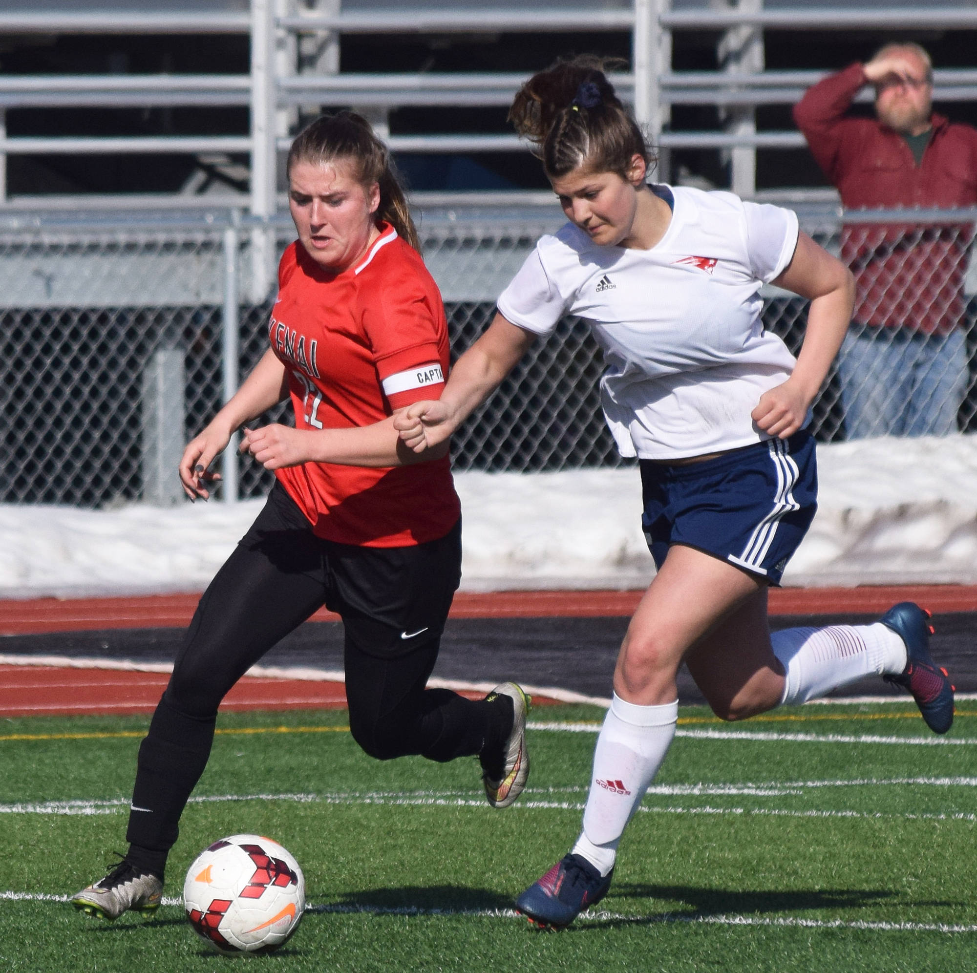 Kenai’s Olivia Brewer races to the ball against North Pole’s Maryn Long Saturday, April 13, 2019, in a nonconference game at Kenai Central High School. (Photo by Joey Klecka/Peninsula Clarion)