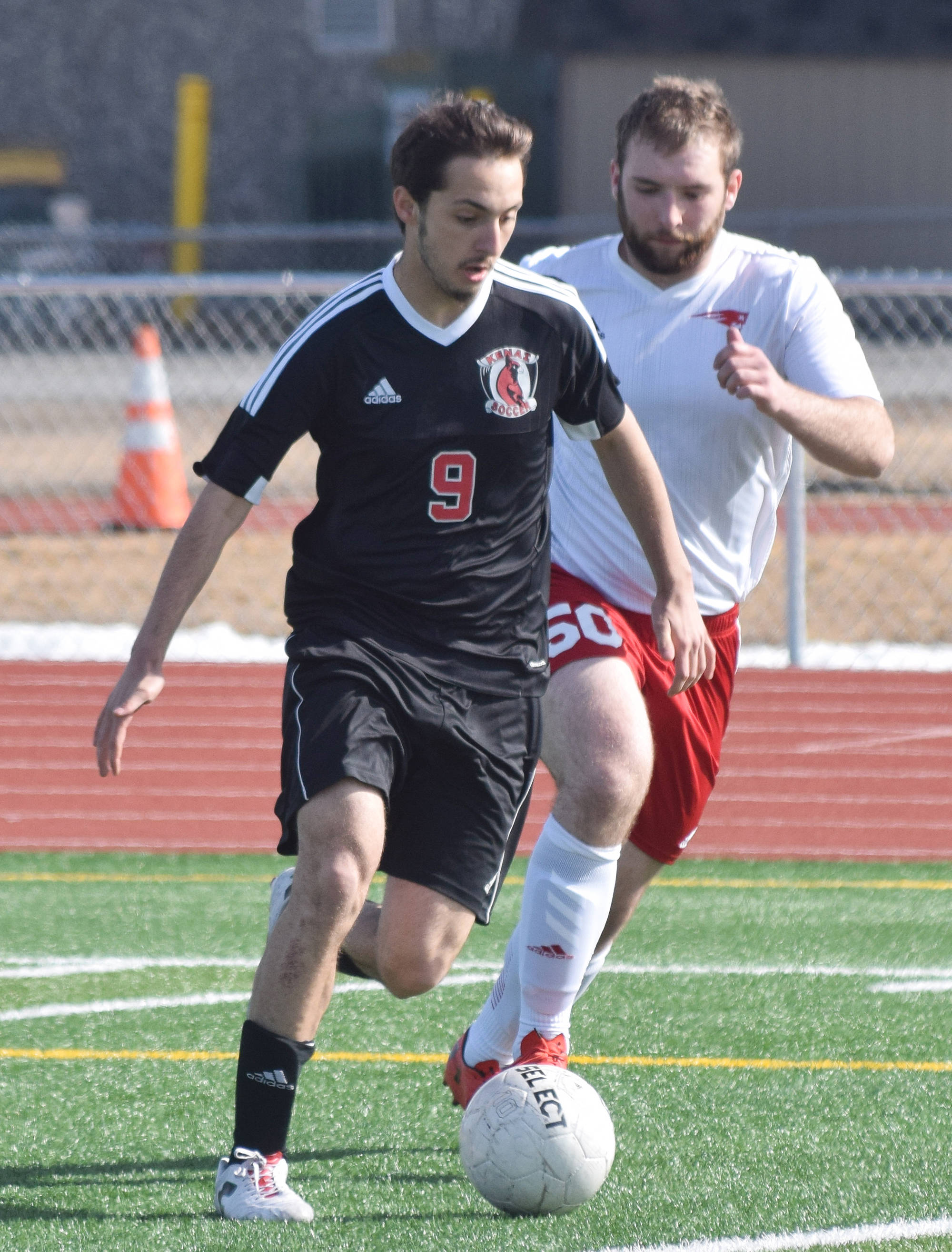 Kenai’s Tomas Levy-Canedo beats North Pole’s Jacob Blanchard to the ball Saturday, April 13, 2019, in a nonconference game at Kenai Central High School. (Photo by Joey Klecka/Peninsula Clarion)