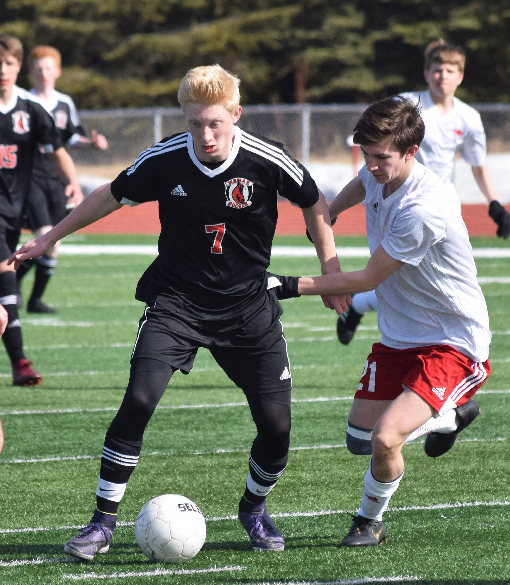 Kenai’s Leif Lofquist looks for a move around North Pole’s Anthony Iles Saturday, April 13, 2019, in a nonconference game at Kenai Central High School. (Photo by Joey Klecka/Peninsula Clarion)