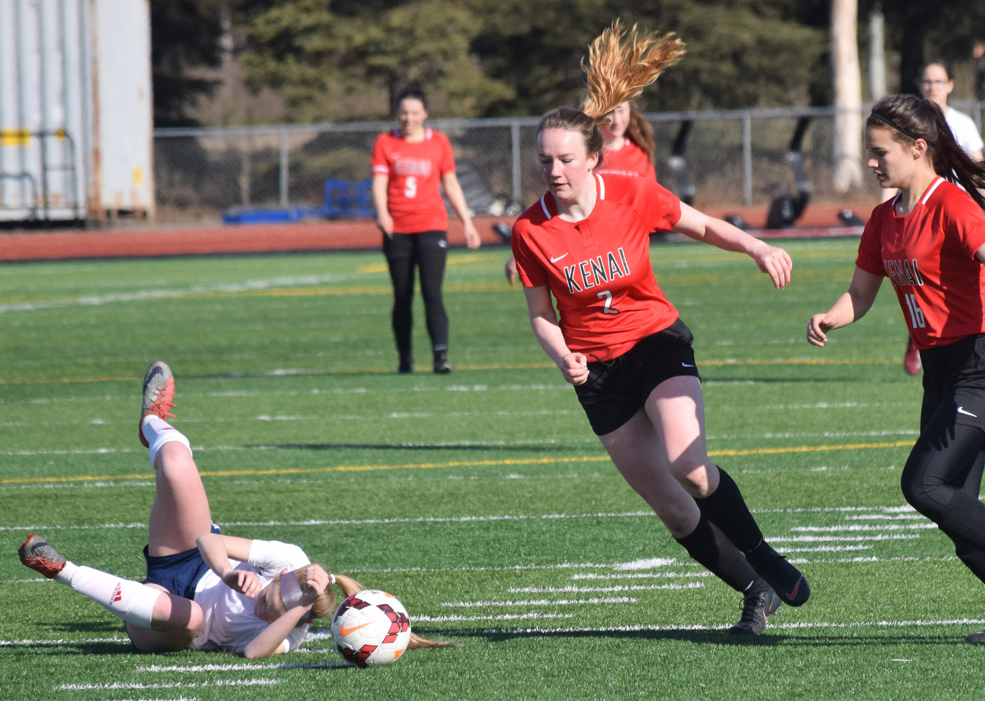 Kenai’s Bethany Morris (right) evades a falling North Pole player Saturday, April 13, 2019, in a nonconference game at Kenai Central High School. (Photo by Joey Klecka/Peninsula Clarion)