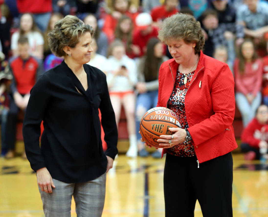 Stacia Rustad, Wasilla High School activities director, presents Wasilla girls basketball head coach Jeannie Hebert-Truax with a basketball commemorating her 500th win as a head coach. (Photo courtesy of Bruce Eggleston)