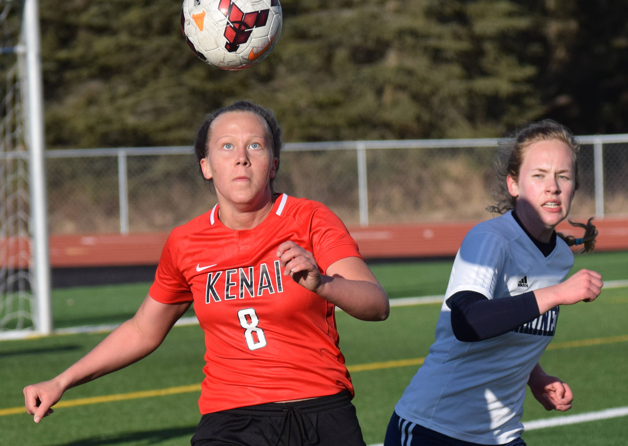 Kenai Central’s Anya Danielson prepares to clear the ball in front of Homer’s Jessica Sonnen on Tuesday, April 16, 2019, at Kenai Central High School in Kenai, Alaska. (Photo by Jeff Helminiak/Peninsula Clarion)