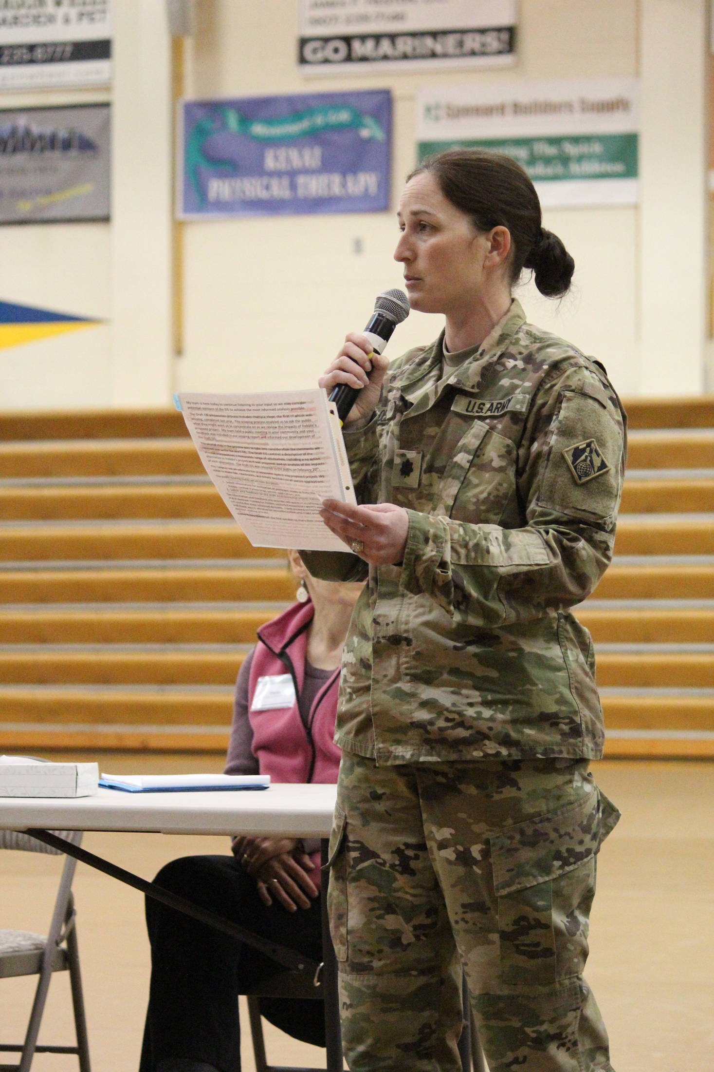 Lieutenant Colonel Penny Bloedel addresses a crowd of people at an April 11, 2019 public hearing hosted by the Army Corps of Engineers to take public comments on the Draft Environmental Impact Statement for the proposed Pebble Mine, held at Homer High School in Homer, Alaska. (Photo by Megan Pacer/Homer News)