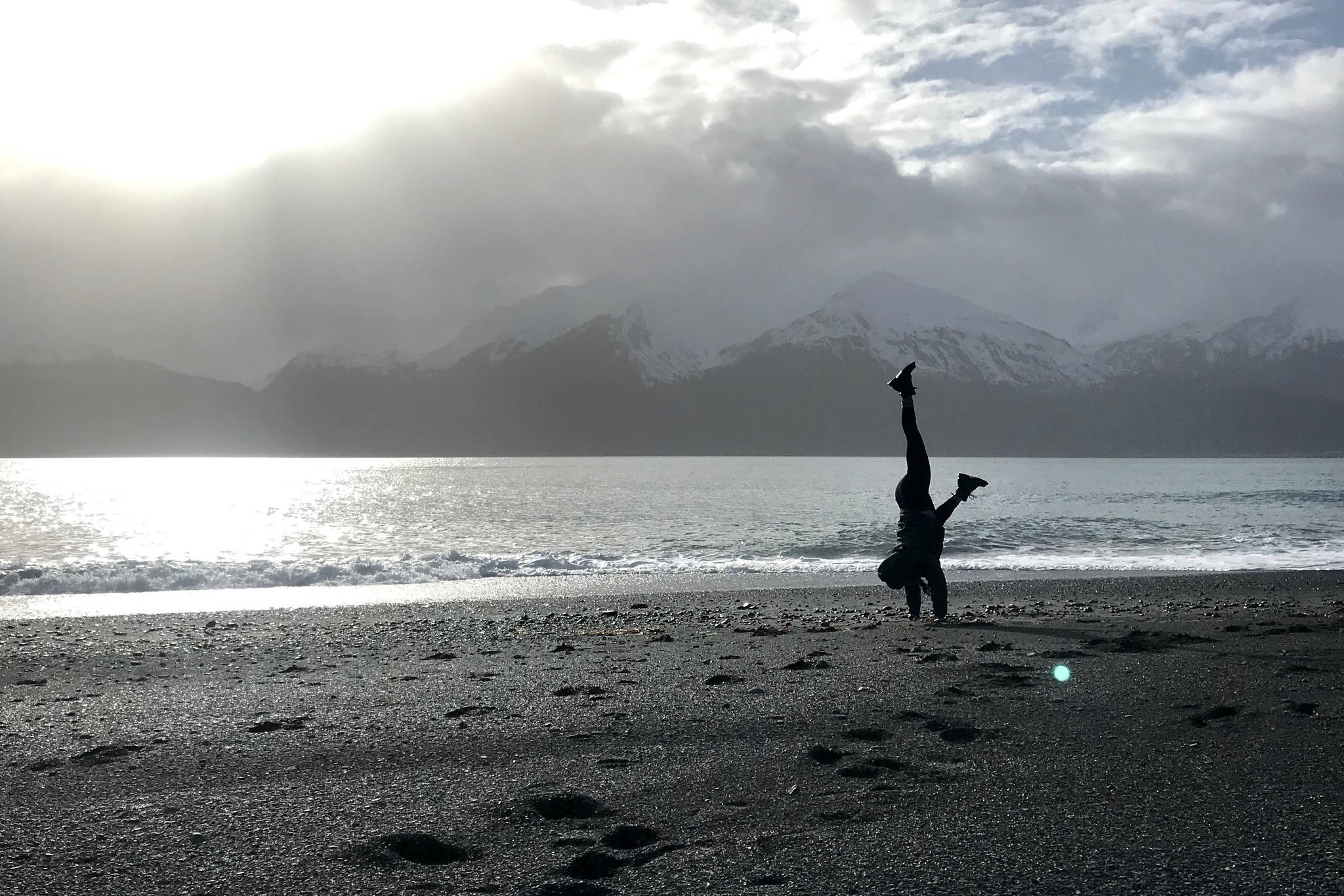 Nikki Aufiero practices a handstand at Fourth of July Beach near Seward, Alaska, in April 2019. (Photo by Kat Sorensen/Peninsula Clarion)