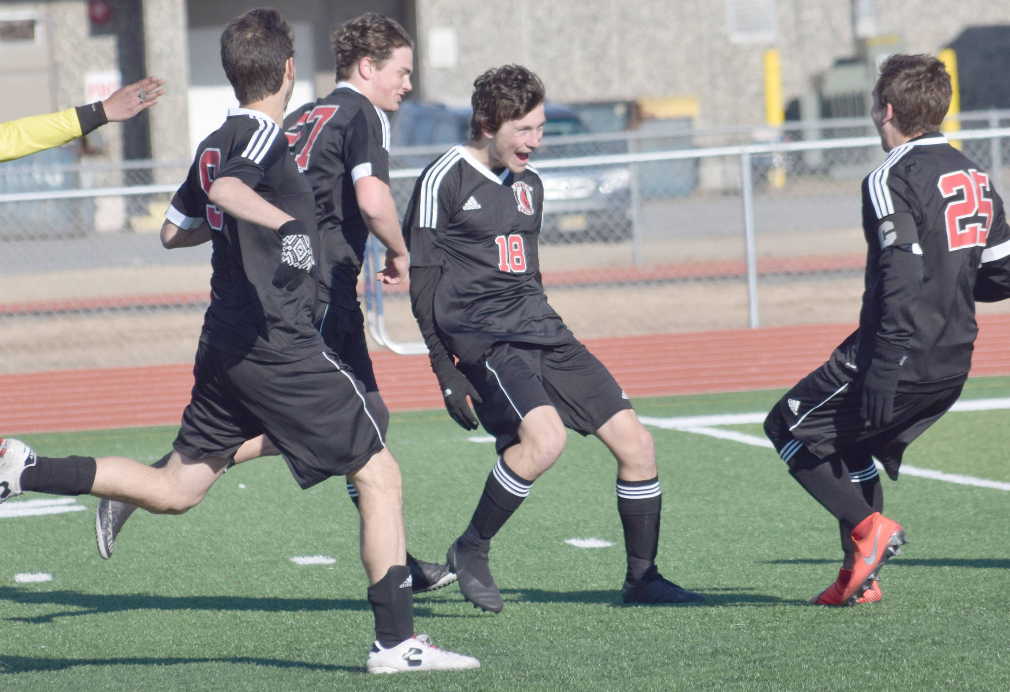Damien Redder (18) celebrates the first of his three goals with teammates Monday, April 22, 2019, at Ed Hollier Field at Kenai Central High School in Kenai, Alaska. (Photo by Jeff Helminiak)