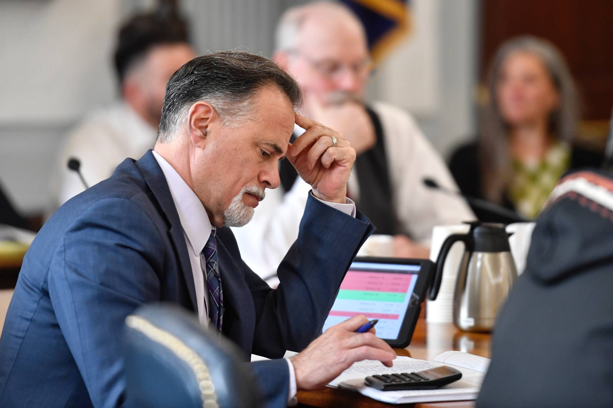 David Teal, Director of the Legislative Finance Division, gives his analysis of Gov. Mike Dunleavy’s state budget to the Senate Finance Committee at the Capitol on Tuesday, Feb. 26, 2019. (Michael Penn | Juneau Empire File)                                Sen. Peter Micciche, R-Soldotna, works a calculator as he and Sen. Bert Stedman, R-Sitka, listen to public testimony on the state budget in the Senate Finance Committee hearing on Friday, April 12, 2019. (Michael Penn | Juneau Empire)