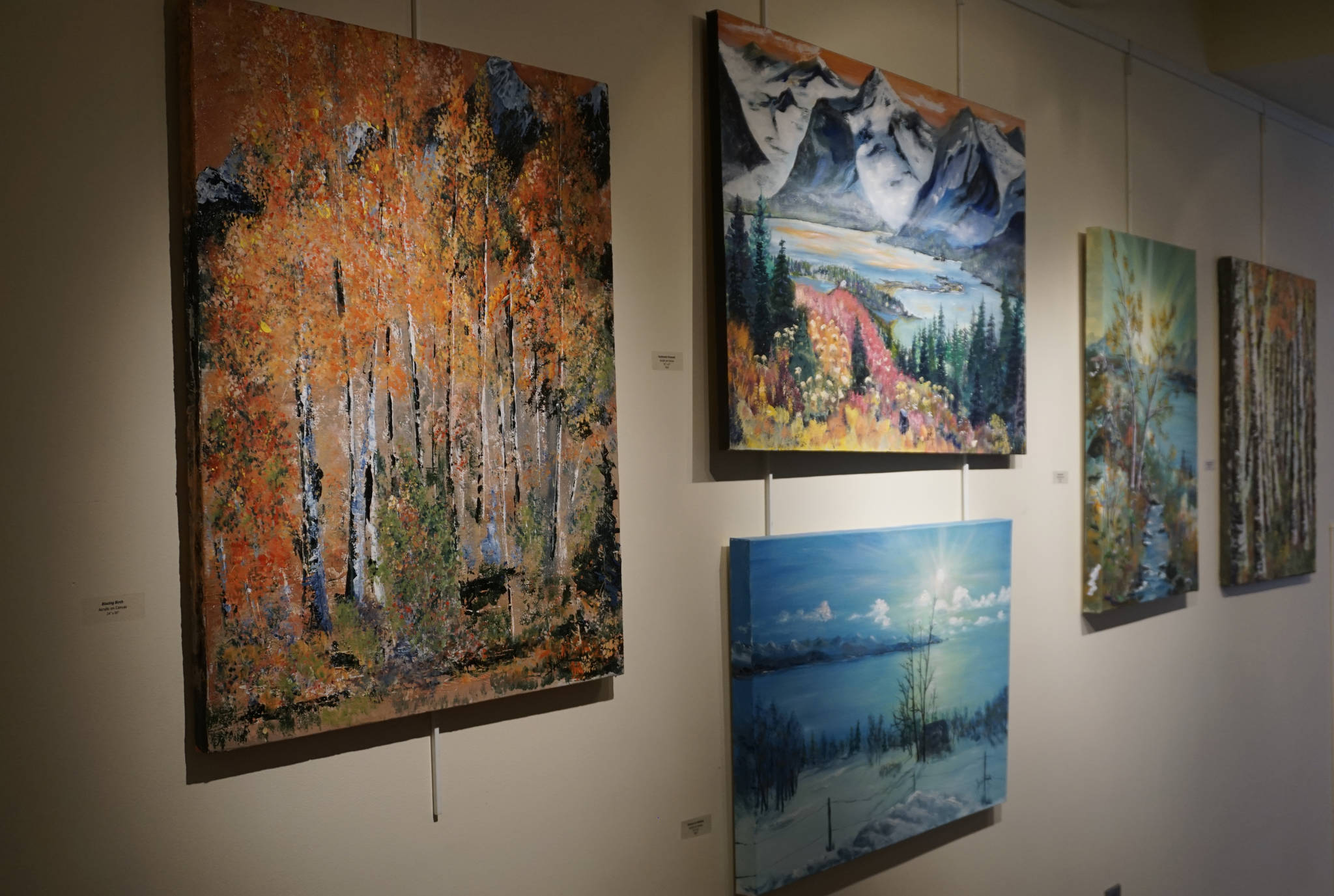 Some of John Fenske’s paintings at the First Friday, April 5, 2019, opening for his retrospective showing at Kachemak Bay Campus in Homer, Alaska. (Photo by Michael Armstrong/Homer News)