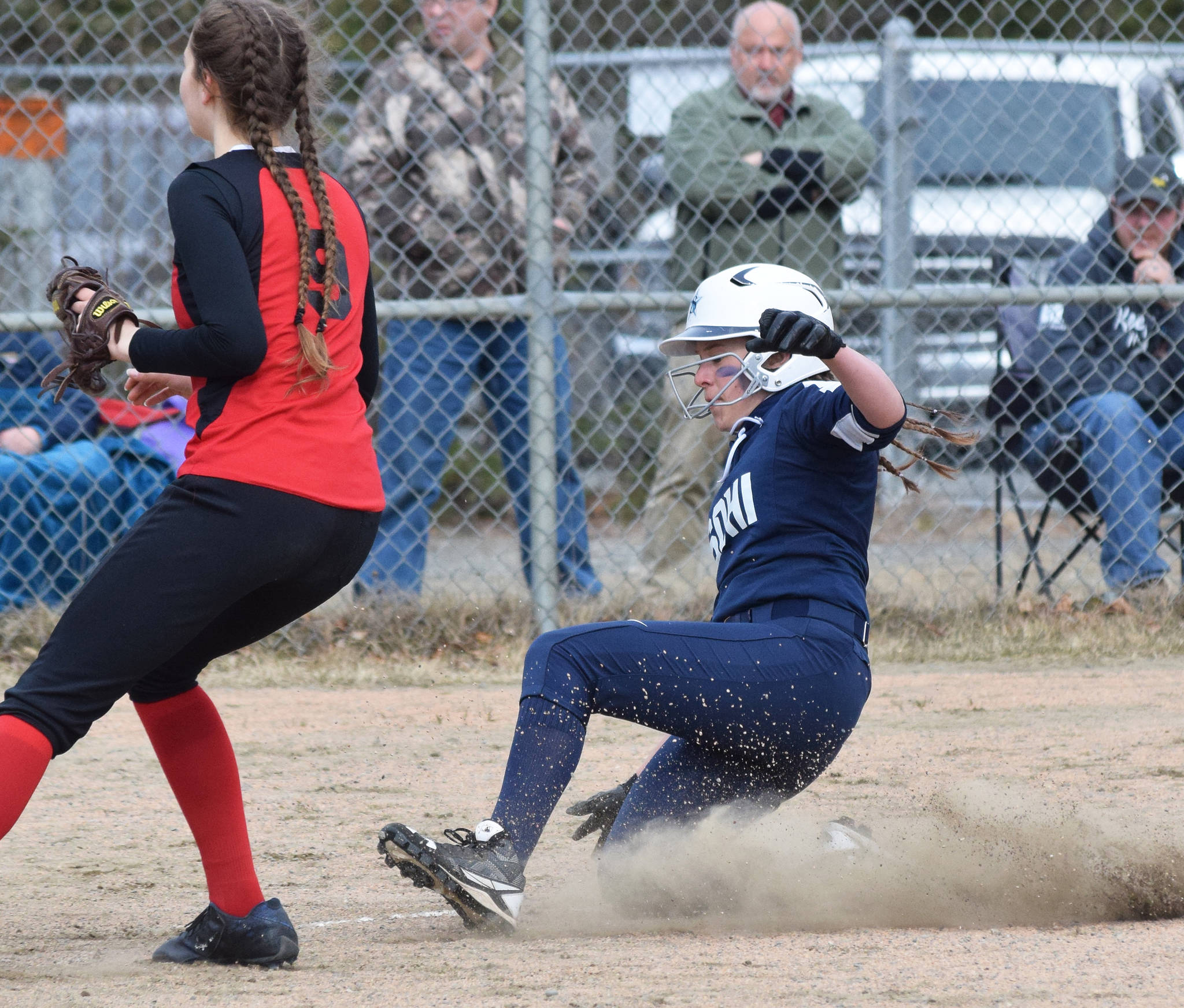 Soldotna’s Bailey Berger slides home safe in front of Kenai Central’s Lexi Reis, Thursday, April 25, 2019, at the Soldotna Softball Fields. (Photo by Joey Klecka/Peninsula Clarion)