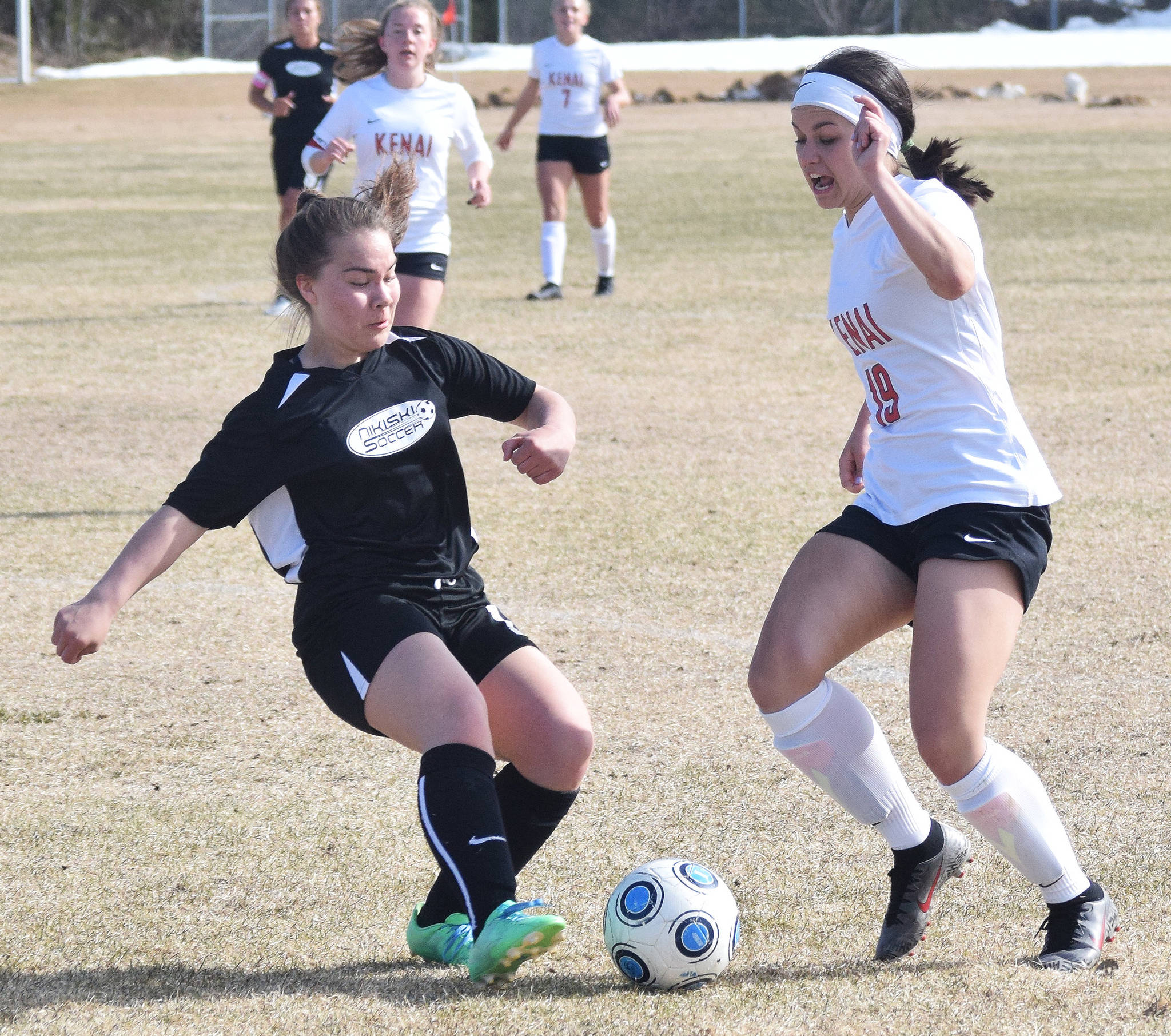 Nikiski’s Rosalie Anderson (left) and Kenai’s Jenna Streiff battle for the ball in a Peninsula Conference game Tuesday, April 30, 2019, at Nikiski High School. (Photo by Joey Klecka/Peninsula Clarion)