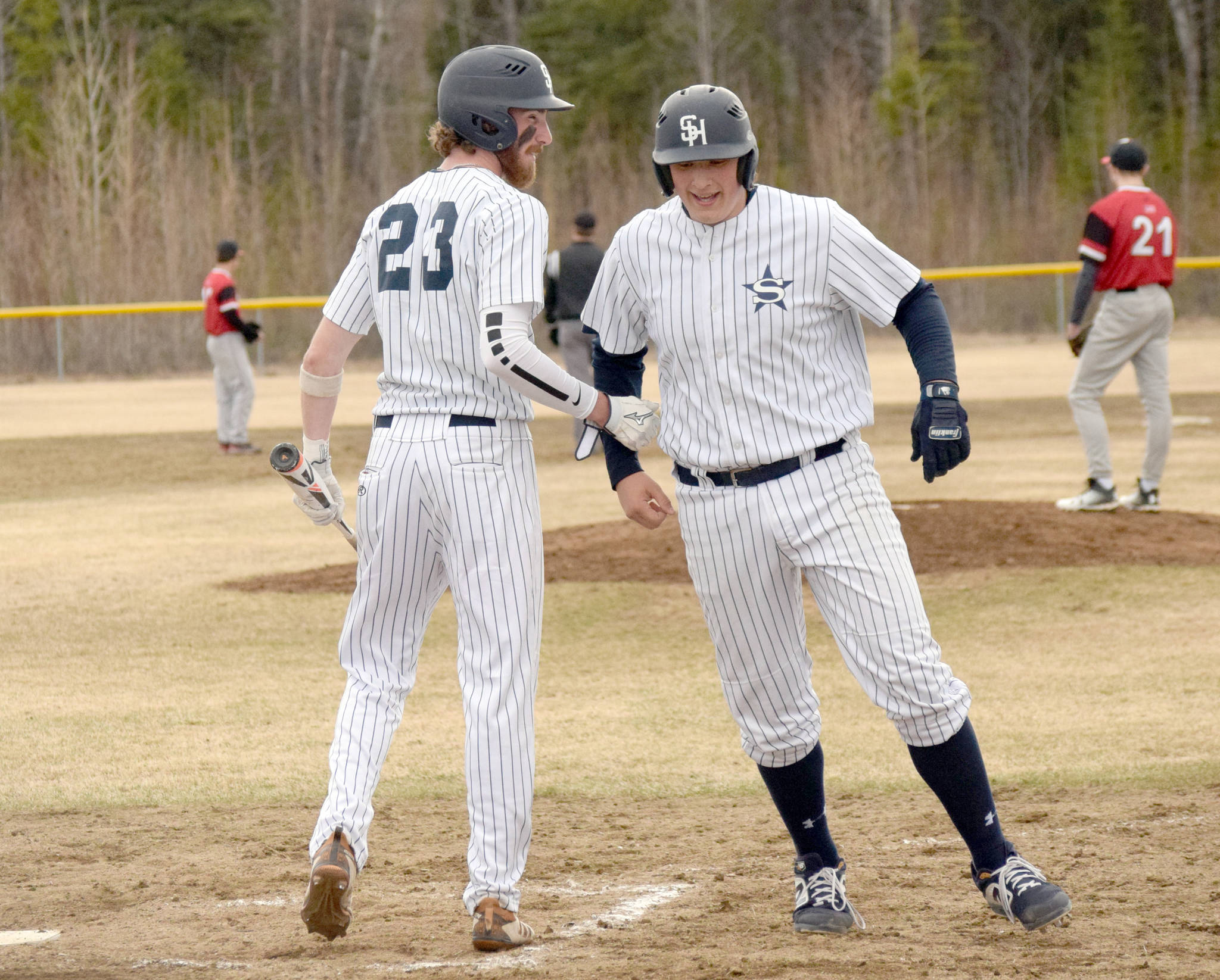 Soldotna’s David Michael (23) congratulates Jacob Boze after Boze hit a two-run home run in the second inning against Kenai Central at the Soldotna Little League fields in Soldotna, Alaska. (Photo by Jeff Helminiak/Peninsula Clarion)