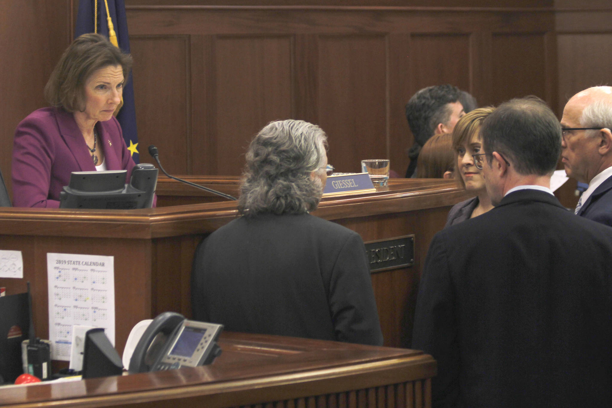 Senate President Cathy Giessel, left, listens to Senate leaders on the floor at the Alaska State Capitol on Wednesday, May 1, 2019. (Alex McCarthy | Juneau Empire)