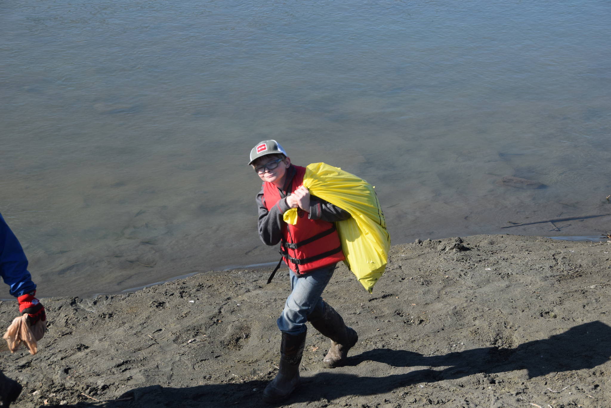 A student from Redoubt Elementary carries his haul back to the pile during the 6th Annual Kids Kenai River Spring Cleanup at Swiftwater Park in Soldotna, Alaska on May 3, 2019. (Photo by Brian Mazurek/Peninsula Clarion)