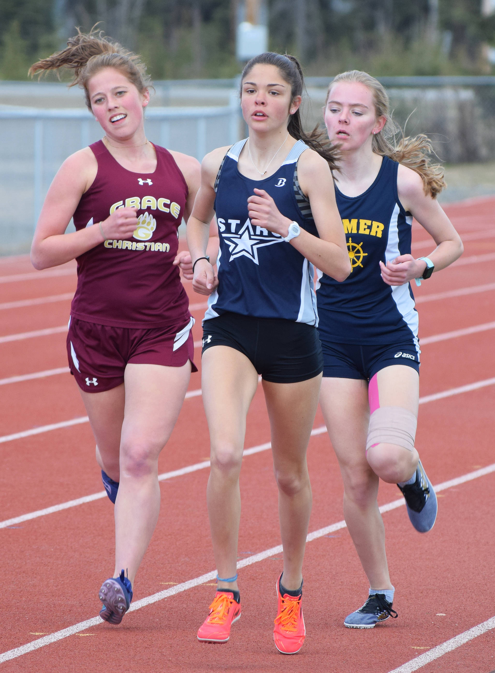 Soldotna’s Erika Arthur (front), Grace Christian’s Grace Annett and Homer’s Brooke Miller run in formation in the girls 1,600 meters Saturday, May 4, 2019, at the Kenai Invitational track meet at Kenai Central High School. (Photo by Joey Klecka/Peninsula Clarion)