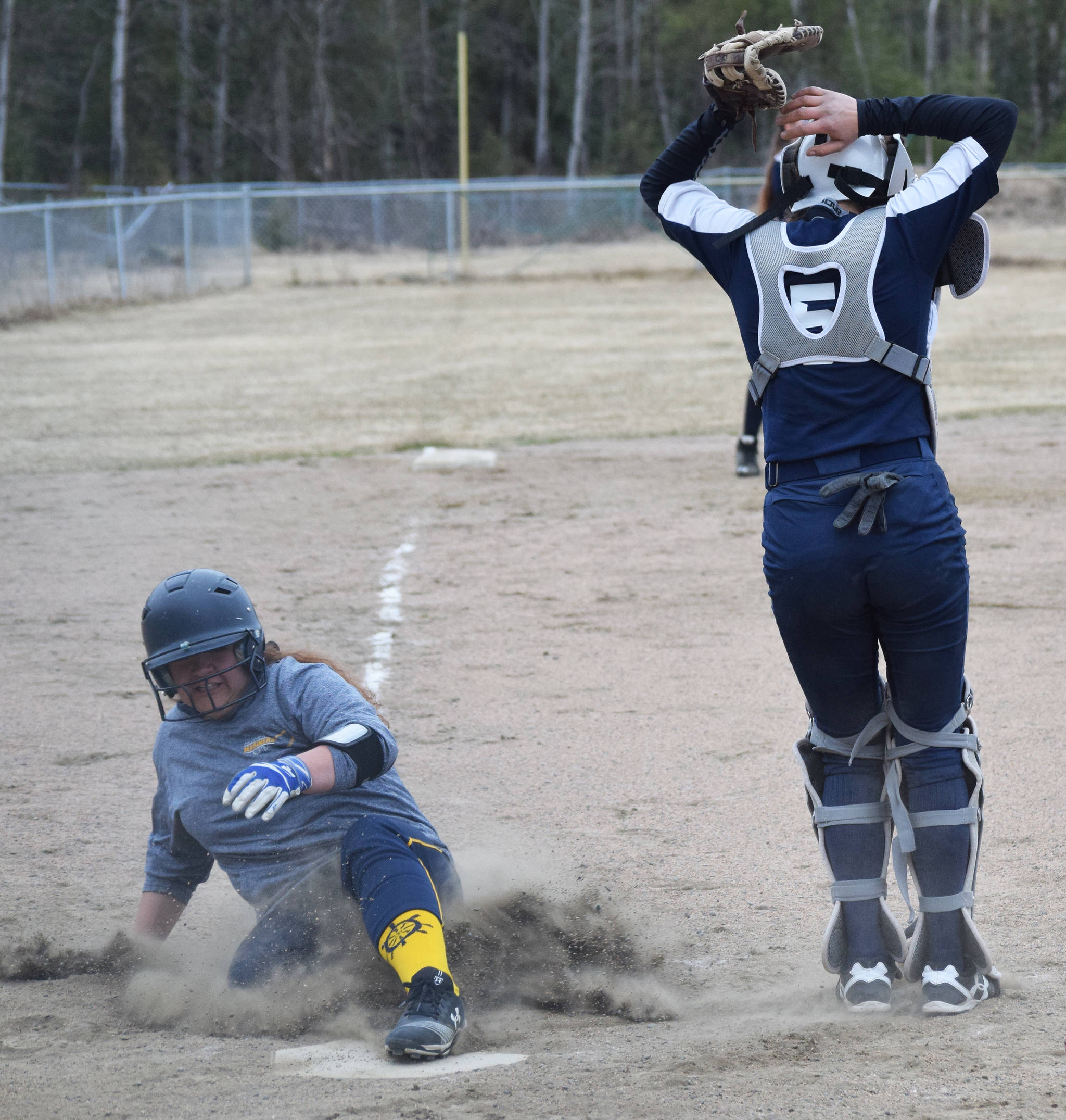 Homer’s Brianna Hetrick slides home behind Soldotna catcher Casey Card Tuesday evening in a Northern Lights Conference game in Soldotna. (Photo by Joey Klecka/Peninsula Clarion)