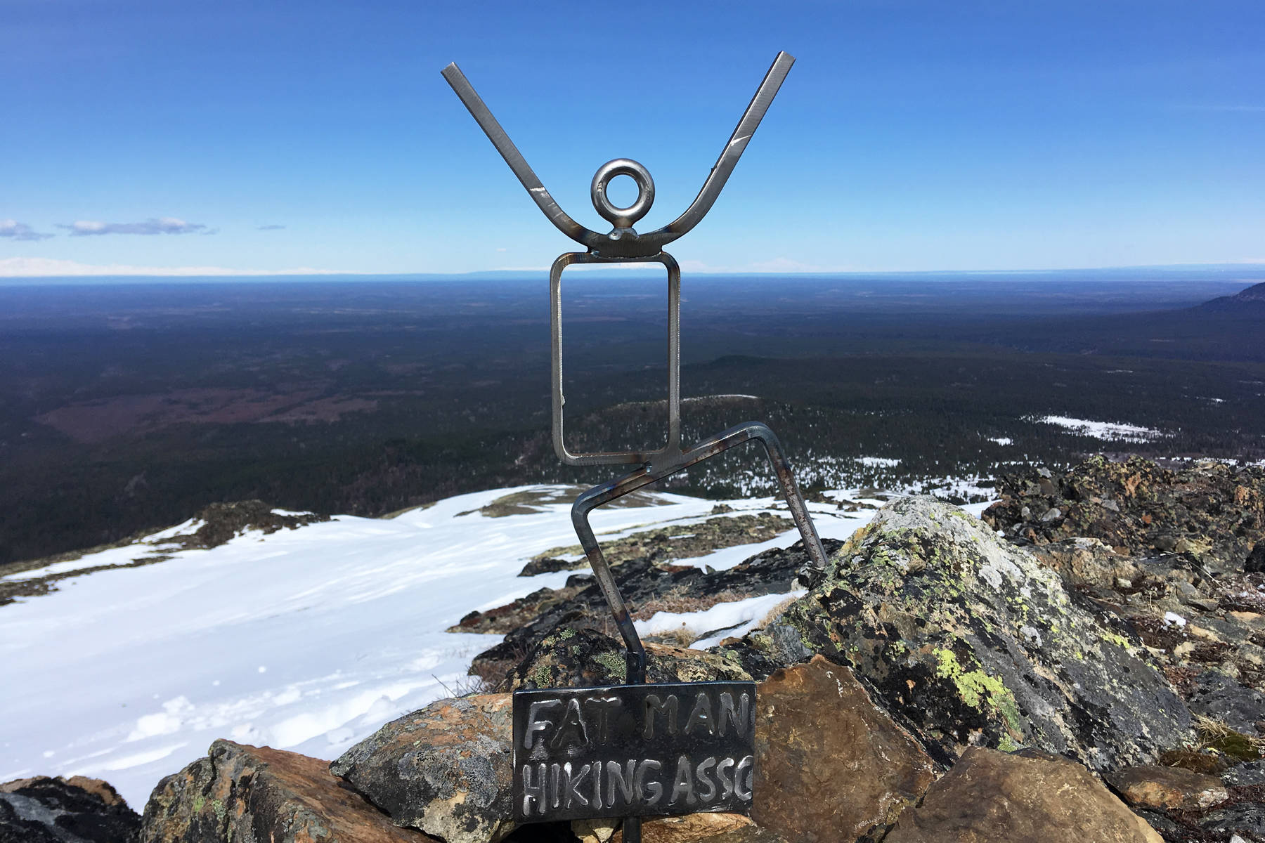 A metal figurine stands atop a peak in the Mystery Hills on the Kenai Peninsula on April 28, 2019. (Photo by Jeff Helminiak/Peninsula Clarion)
