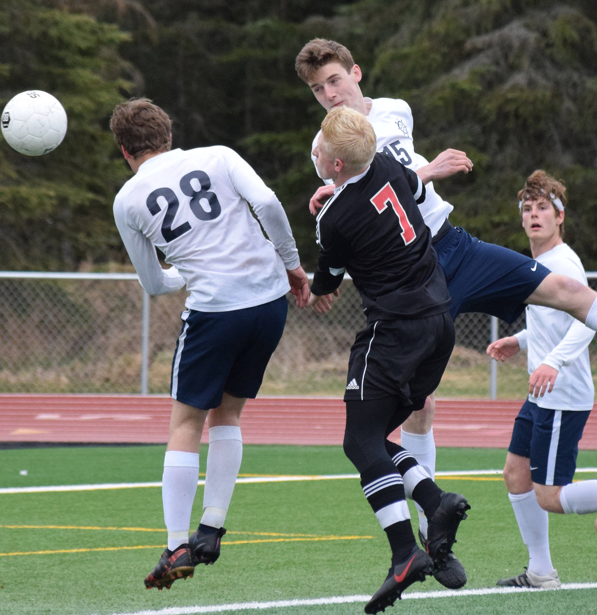 Kenai’s Leif Lofquist (7) gets sandwiched between Homer’s Phinny Weston (28) and Ethan Pitzman Thursday, May 9, 2019, in Kenai, Alaska. (Photo by Joey Klecka/Peninsula Clarion)