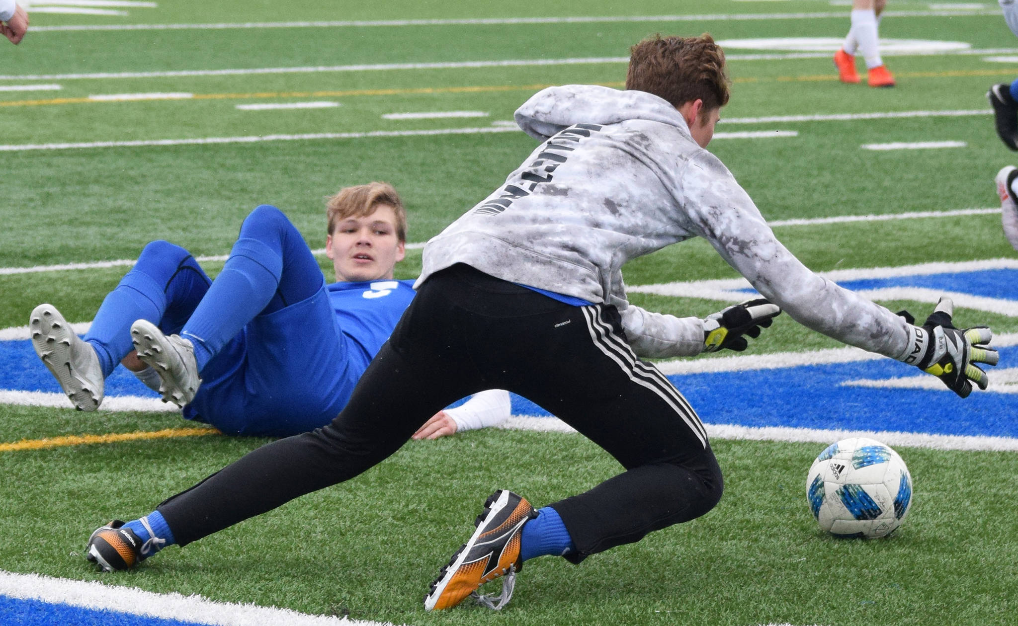 Soldotna’s Rory Nelson watches as SoHi goalkeeper Colton Sorhus (forwar) falls on the ball Saturday, May 11, 2019, against Homer in a Peninsula Conference game in Soldotna, Alaska. (Photo by Joey Klecka/Peninsula Clarion)