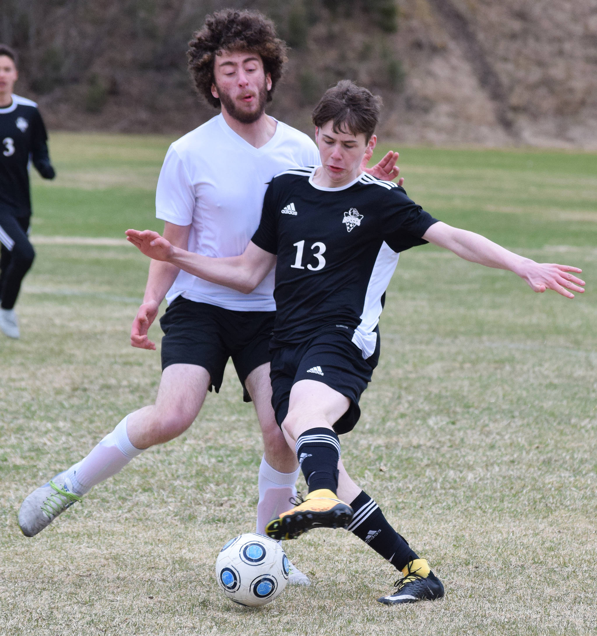 Nikiski’s Isaiah Gray (13) battles for the ball with a Houston defender Friday, May 10, 2019, in a nonconference game in Nikiski, Alaska. (Photo by Joey Klecka/Peninsula Clarion)