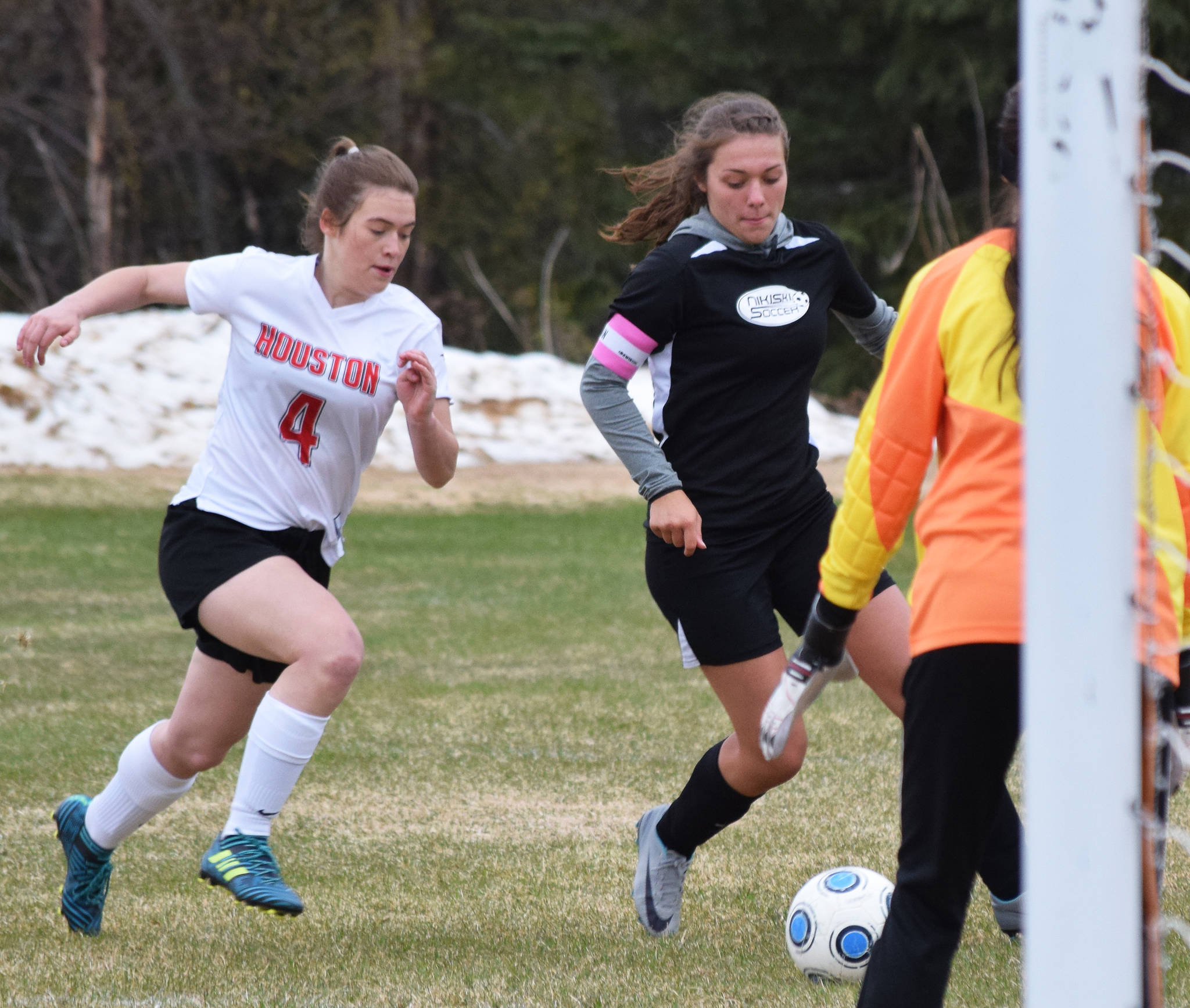 Nikiski’s Emma Wik charges toward the Houston goal with Houston defender Kyla Nicol on her heels Friday, May 10, 2019, in a nonconference game in Nikiski, Alaska. (Photo by Joey Klecka/Peninsula Clarion)