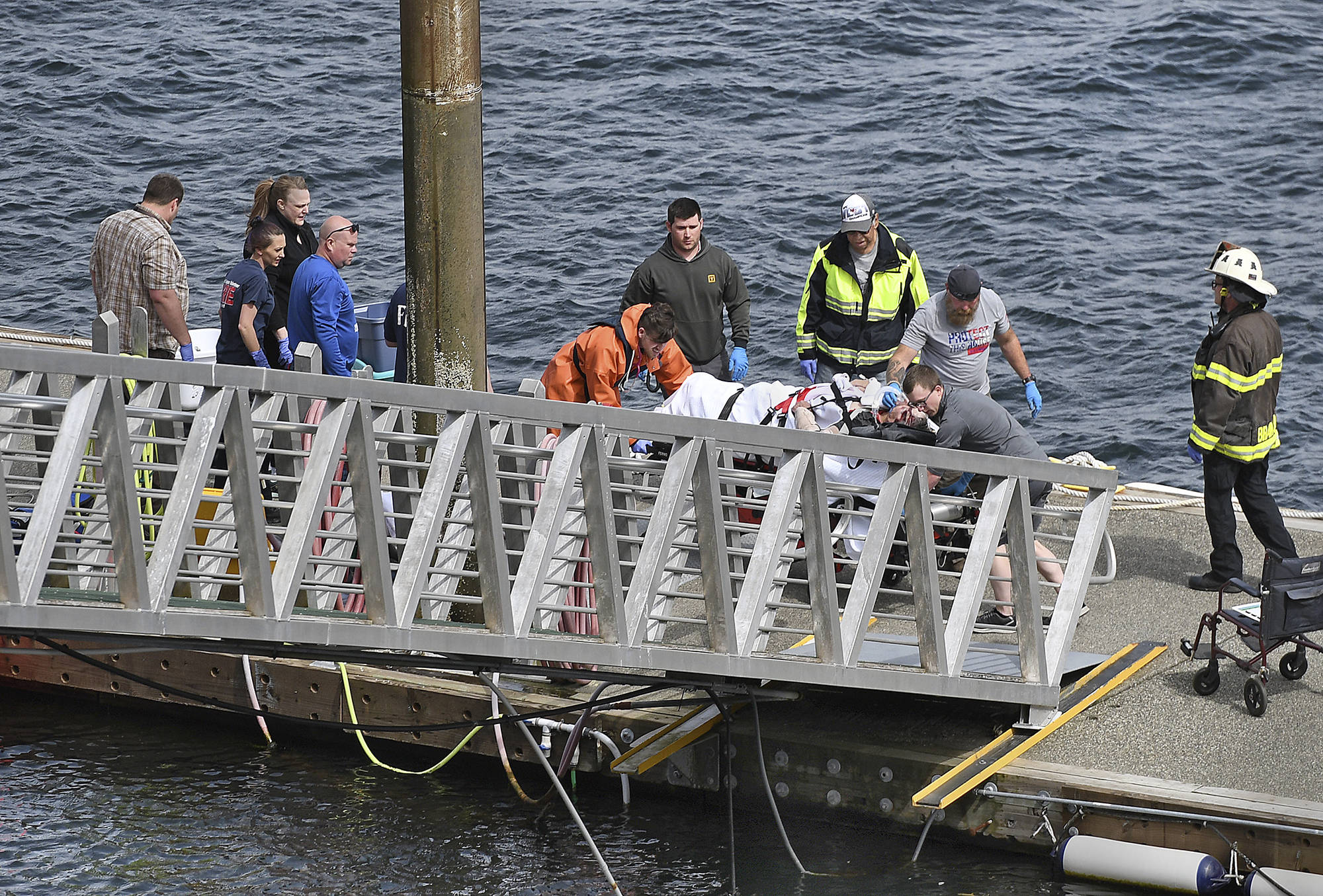 Emergency response crews transport an injured passenger to an ambulance at the George Inlet Lodge docks, Monday, May 13, 2019, in Ketchikan, Alaska. The passenger was from one of two sightseeing planes reported down in George Inlet early Monday afternoon and was dropped off by a U.S. Coast Guard 45-foot response boat. (Dustin Safranek/Ketchikan Daily News via AP)