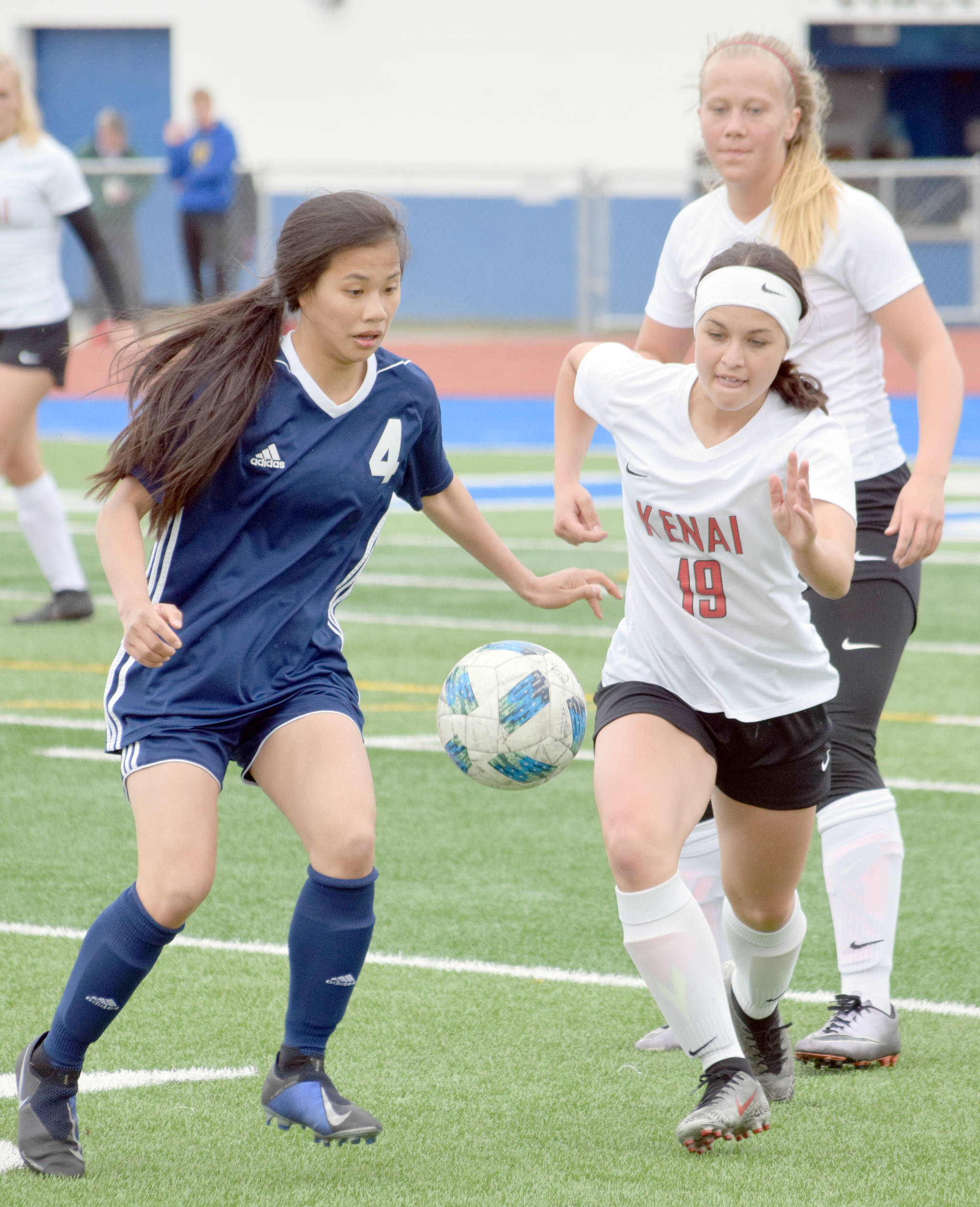 Soldotna’s Meijan Leaf and Kenai Central’s Jenna Streiff battle for the ball in front of Kenai Central’s Anya Danielson on Monday, May 6, 2019, at Soldotna High School. (Photo by Jeff Helminiak/Peninsula Clarion)