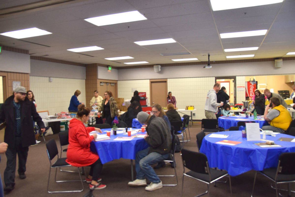 Volunteers and clients enjoy hot meals together during Project Homeless Connect at the Soldotna Regional Sports Complex on Wednesday, Jan. 23, 2019. (Photo by Brian Mazurek/Peninsula Clarion)
