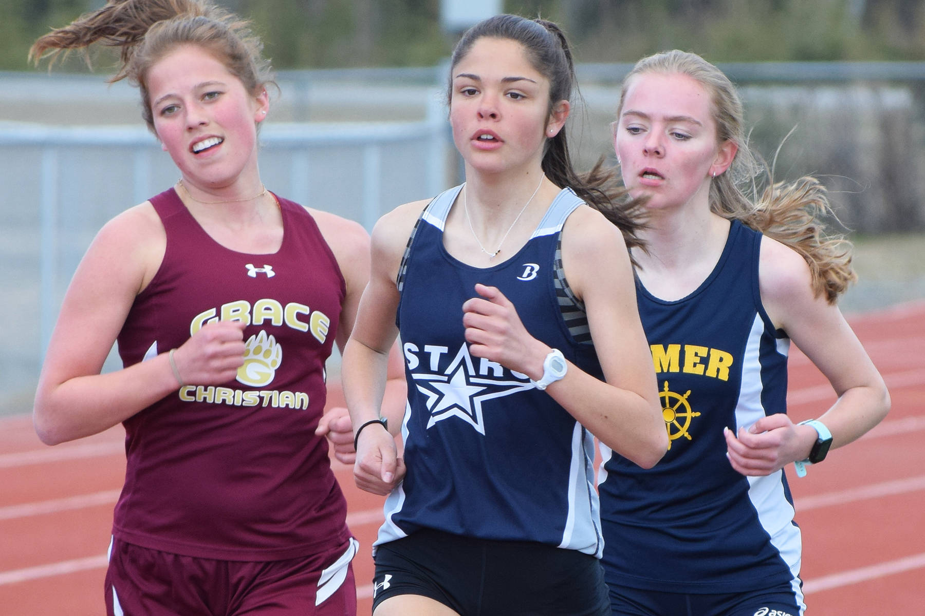 Soldotna’s Erika Arthur (front), Grace Christian’s Grace Annett and Homer’s Brooke Miller run in formation in the girls 1,600 meters Saturday, May 4, 2019, at the Kenai Invitational track meet at Kenai Central High School. (Photo by Joey Klecka/Peninsula Clarion)