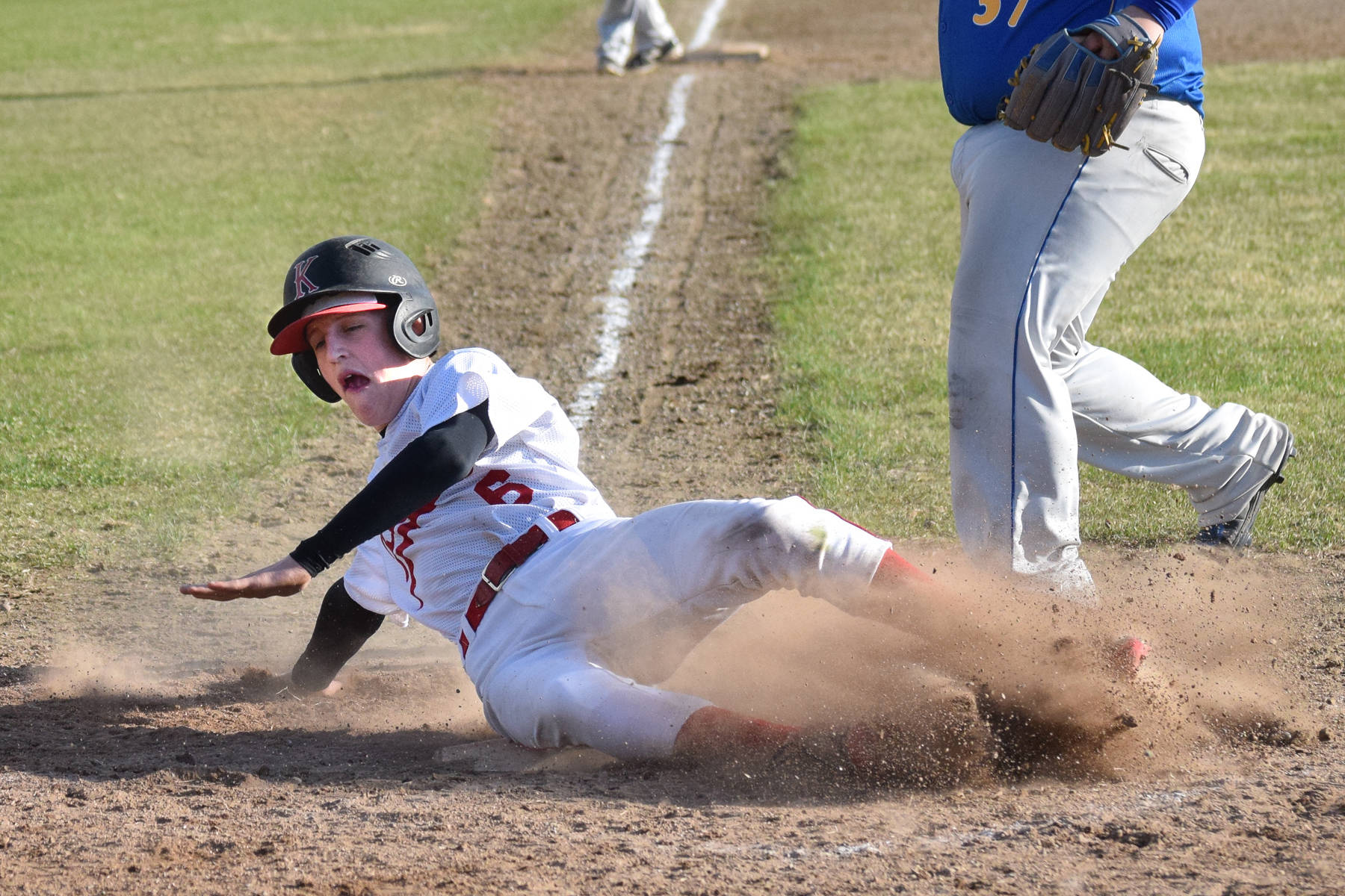 Kenai’s Jaryn Zoda slides home safely in a conference game against Kodiak Thursday, May 16, 2019, at the Kenai Little League Fields in Kenai, Alaska. (Photo by Joey Klecka/Peninsula Clarion)