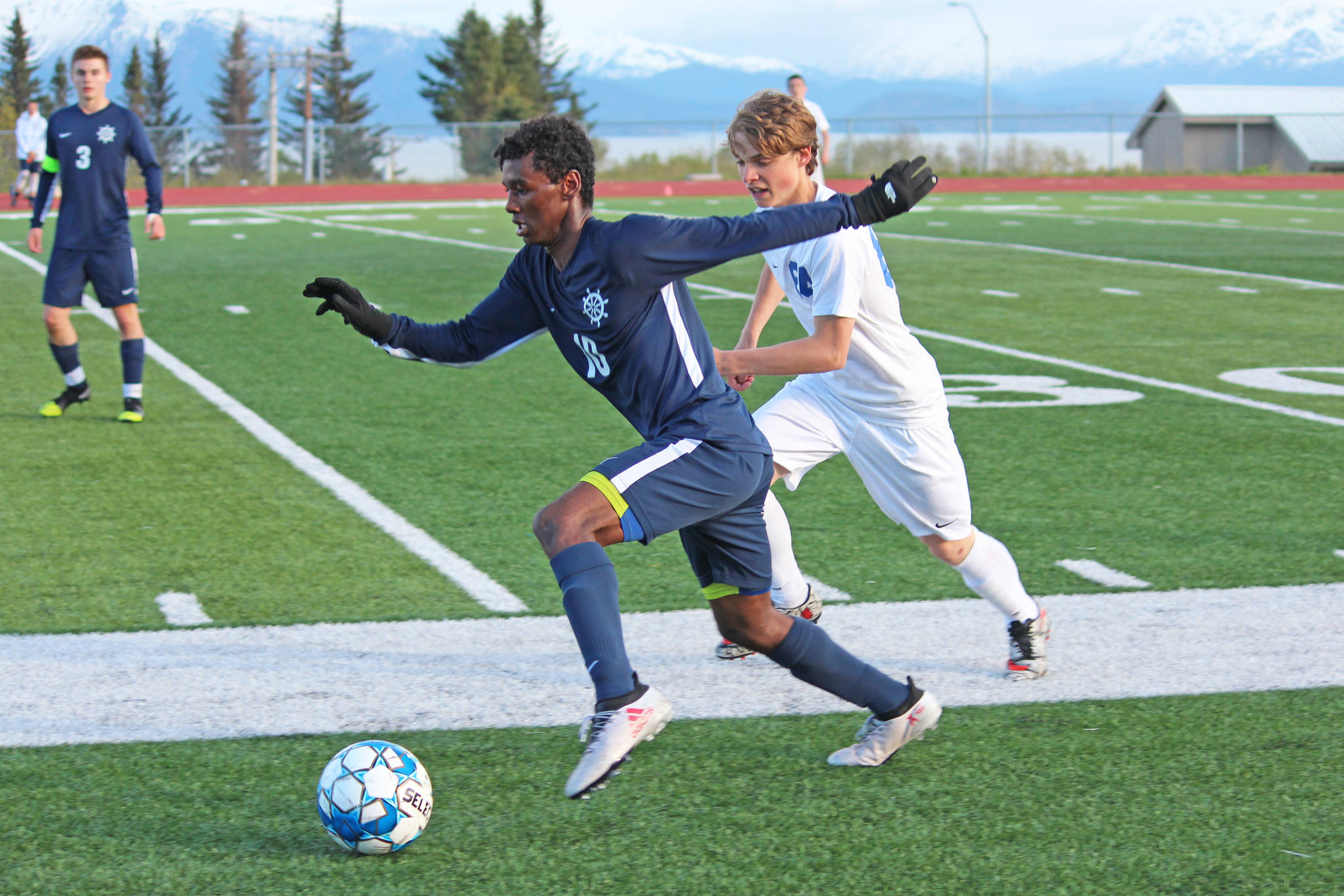 Homer’s Eyoab Knapp takes the ball up the field under pressure from Soldotna’s Quin Cox during the semi-final game of the Peninsula Conference Soccer Tournament on Friday, May 17, 2019 at Homer High School in Homer, Alaska. (Photo by Megan Pacer/Homer News)
