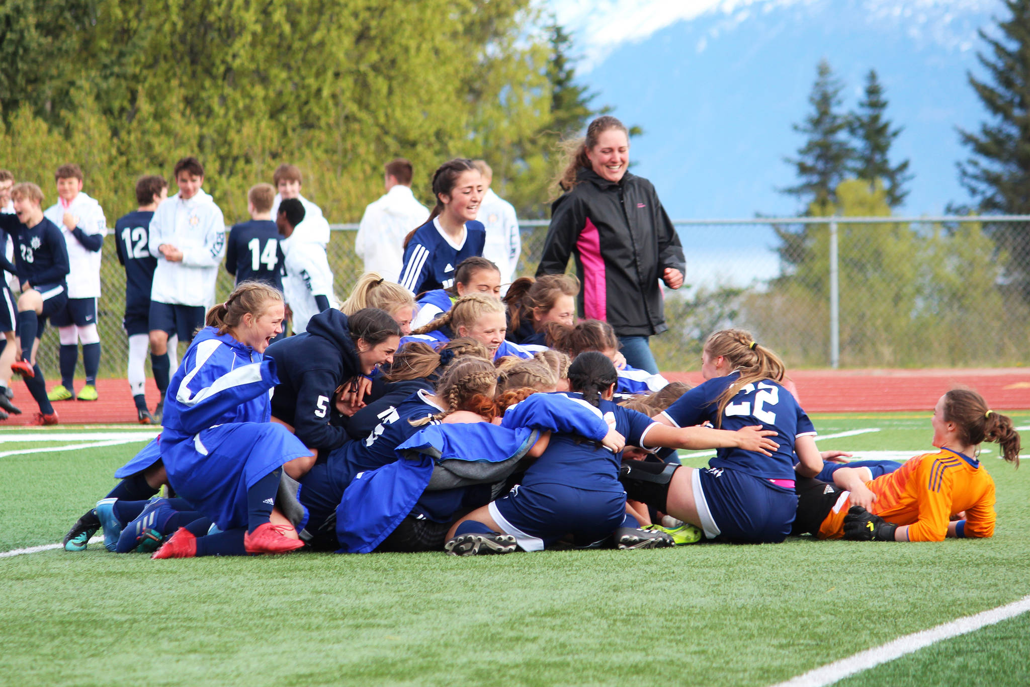 The Homer girls soccer team celebrates its 4-3 win over Kenai Central High School in the semi-final match of the Peninsula Conference Soccer Tournament on Friday, May 17, 2019 at Homer High School in Homer, Alaska. They game went into overtime and two rounds of penalty kicks before a winner was declared. (Photo by Megan Pacer/Homer News)