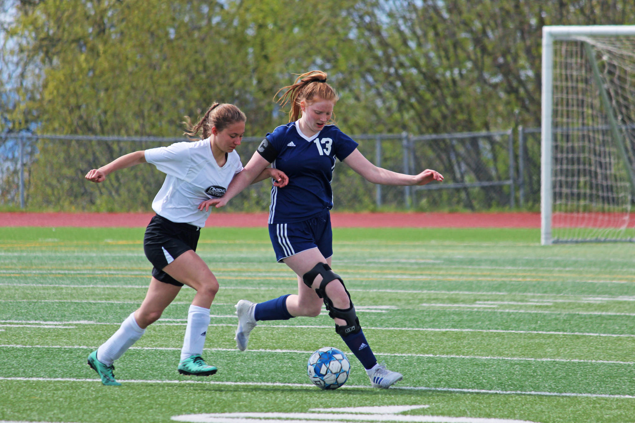 Nikiski’s America Jeffreys tries to snag the ball from Soldotna’s Kianna Holland during a game Friday, May 17, 2019 during the Peninsula Conference Soccer Tournament at Homer High School in Homer, Alaska. Soldotna advanced to the championship game on Saturday with an 11-0 win over Nikiski. (Photo by Megan Pacer/Homer News)
