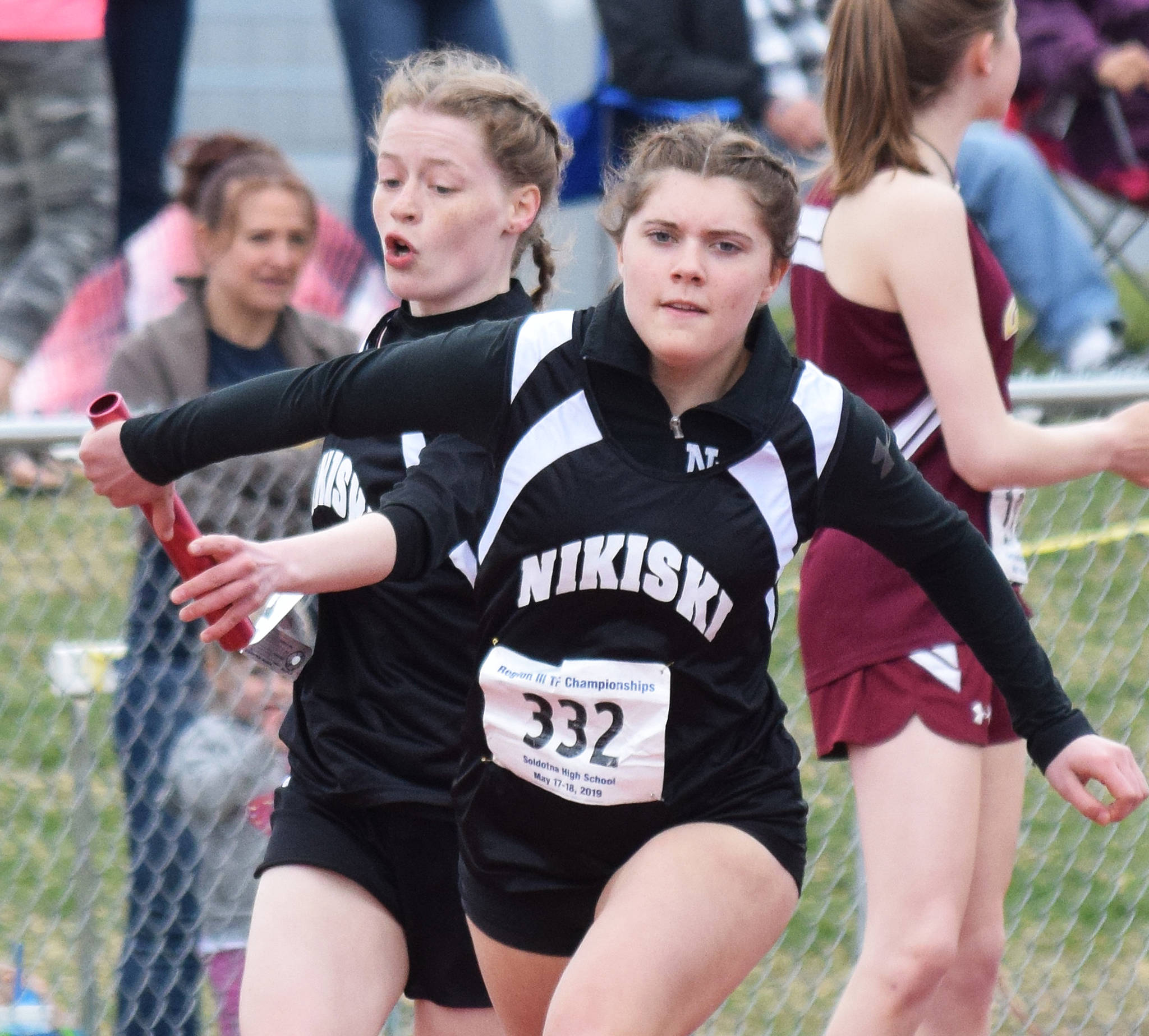 Nikiski’s Sidney Epperheimer passes the baton off to teammate Shylea Freeman in the Class 3A girls 800-meter relay Saturday at the Region III Track and Field championships in Soldotna. (Photo by Joey Klecka/Peninsula Clarion)