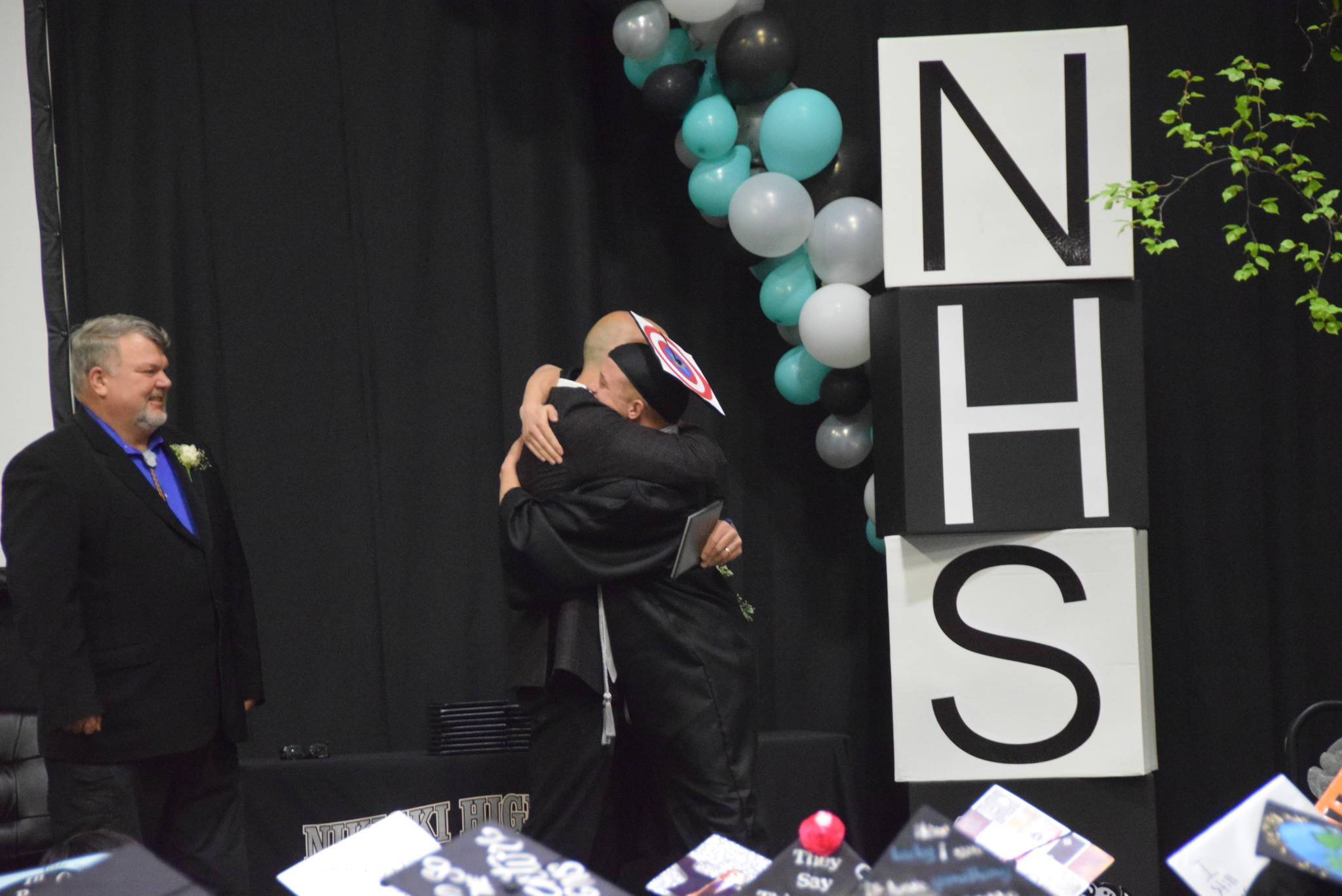 Justin Cox hugs principal Dan Carstens before receiving his diploma during the 2019 Nikiski High School graduation in Nikiski, Alaska on May 20, 2019. (Photo by Brian Mazurek/Peninsula Clarion)