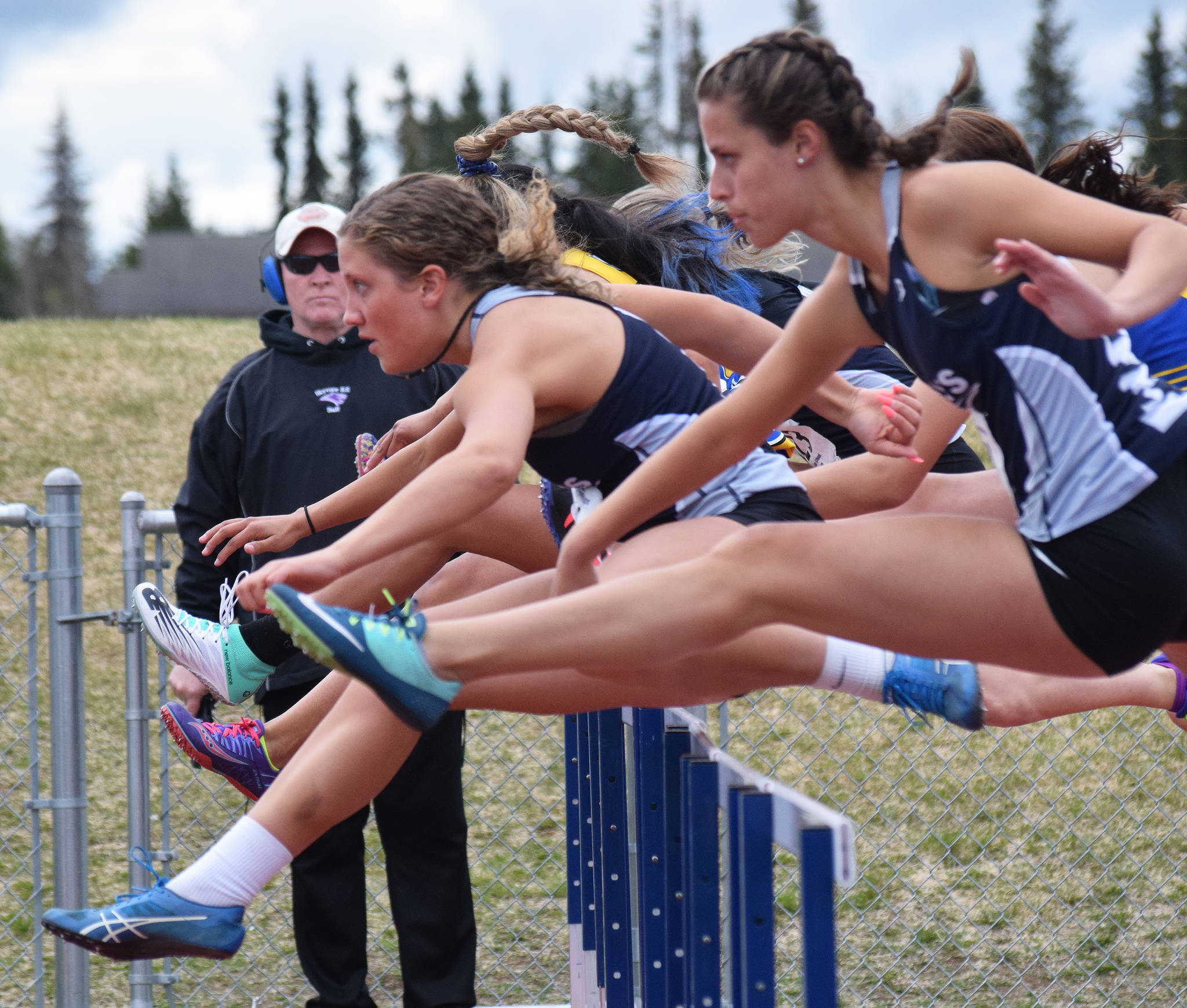 Soldotna’s Kylie Ness (left) and teammate Sophie Thomas lead the pack over the first hurdle in the Class 3A girls 100-meter hurdles Saturday, May 18, 2019, at the Region III Track and Field Championships in Soldotna, Alaska. (Photo by Joey Klecka/Peninsula Clarion)